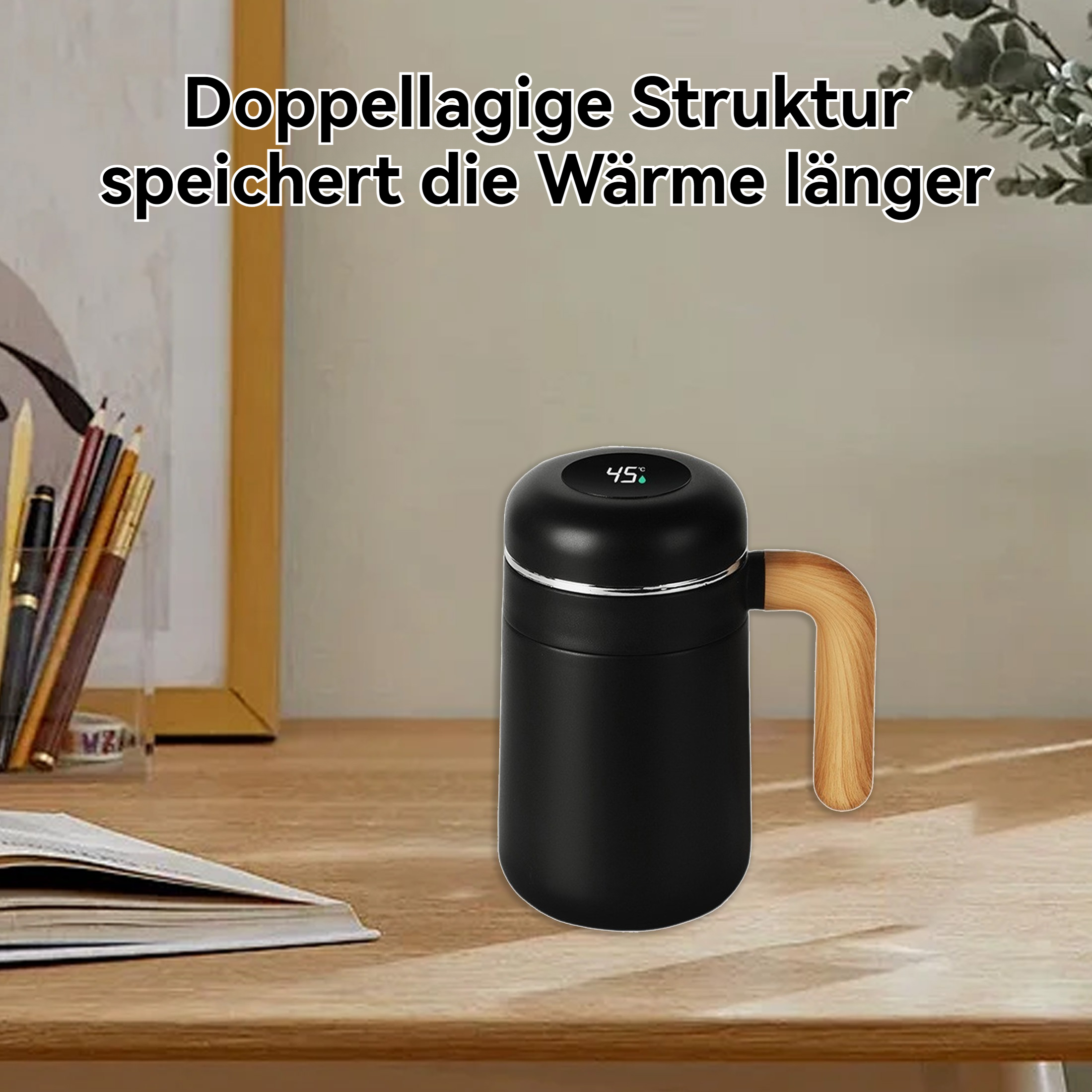 Auf einem Holztisch steht ein schwarzer Reisebecher mit Holzgriff. Ein Buch, Stifte und ein gerahmtes Bild sind ebenfalls zu sehen.