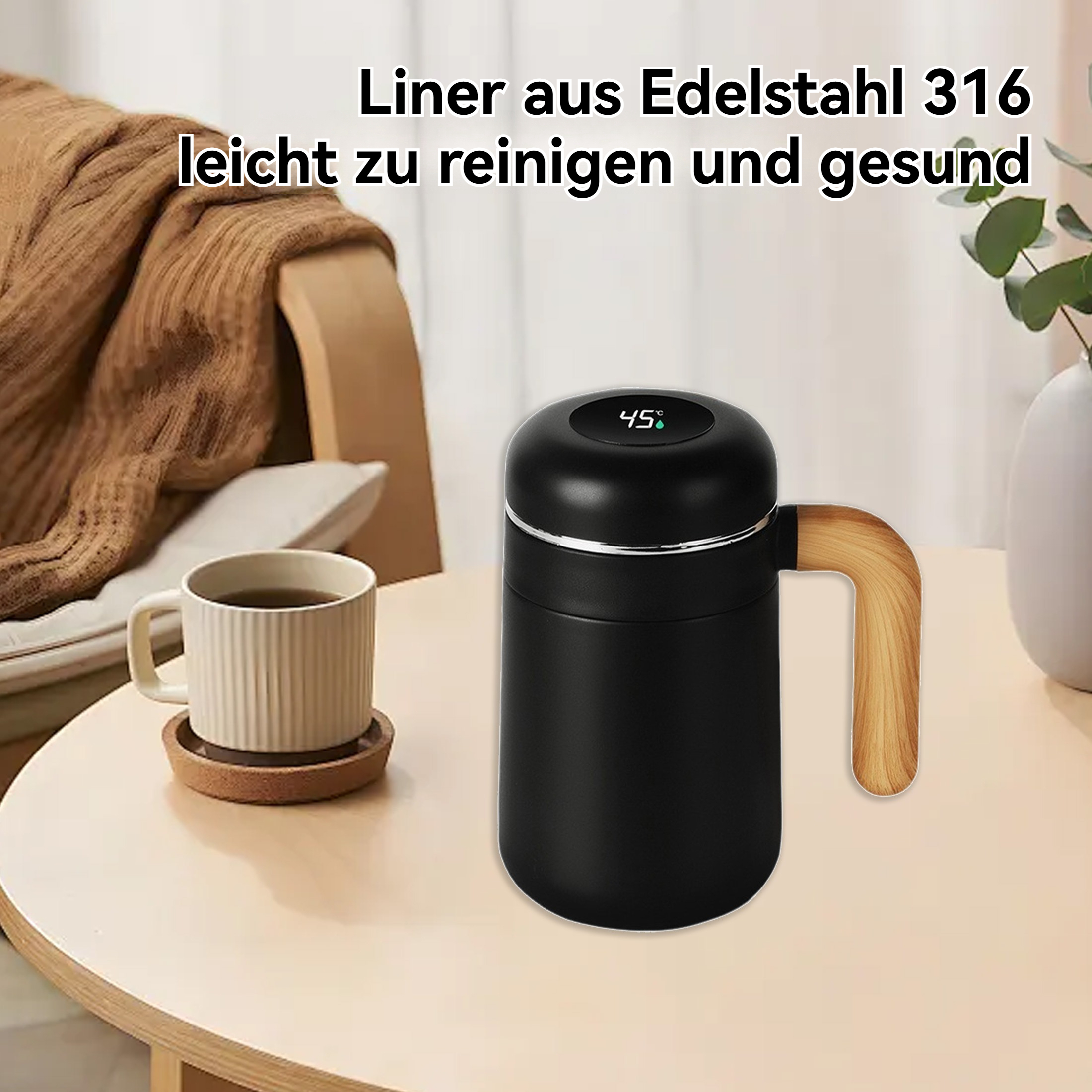Ein schwarzer Isolierbecher mit Holzgriff steht auf einem Tisch neben einer Kaffeetasse.