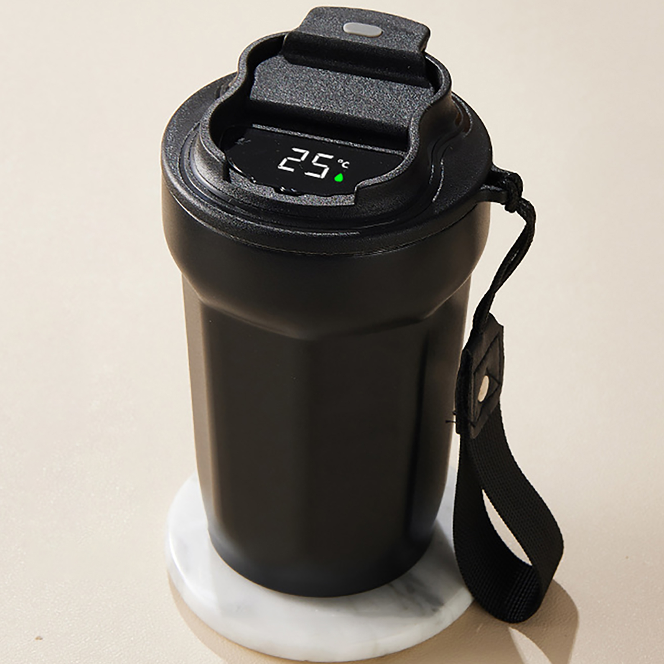 Schwarze isolierte Wasserflasche mit digitaler Temperaturanzeige, die 25°C anzeigt. Sie hat einen schwarzen Riemen und steht auf einem weißen Untersetzer.