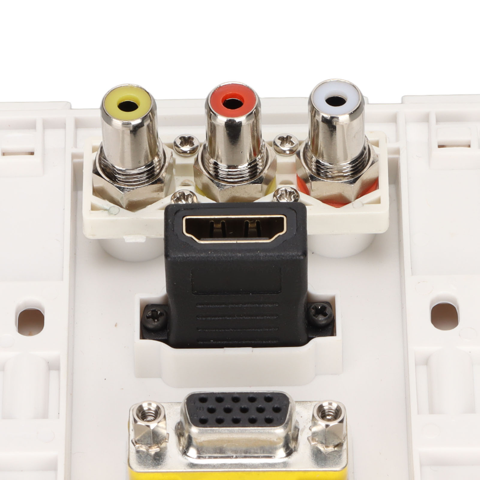 Nahaufnahme einer weißen Wandplatte mit gelben, roten und weißen Anschlüssen, einem schwarzen HDMI-Adapter und einem VGA-Anschluss.