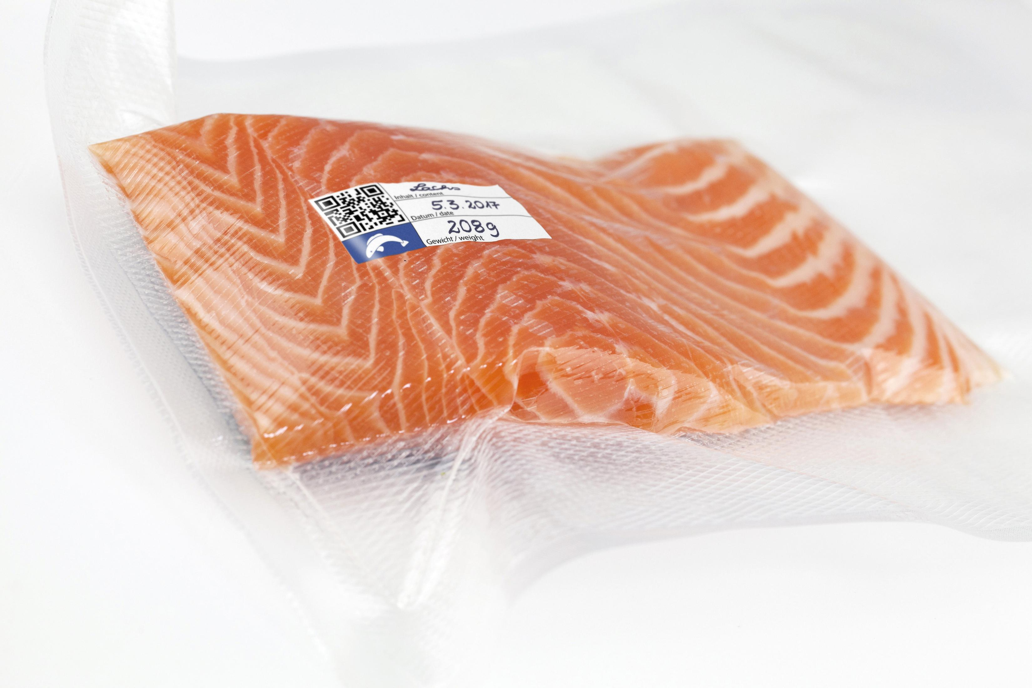 Filetto di salmone sottovuoto con etichetta con peso e data, su sfondo bianco.