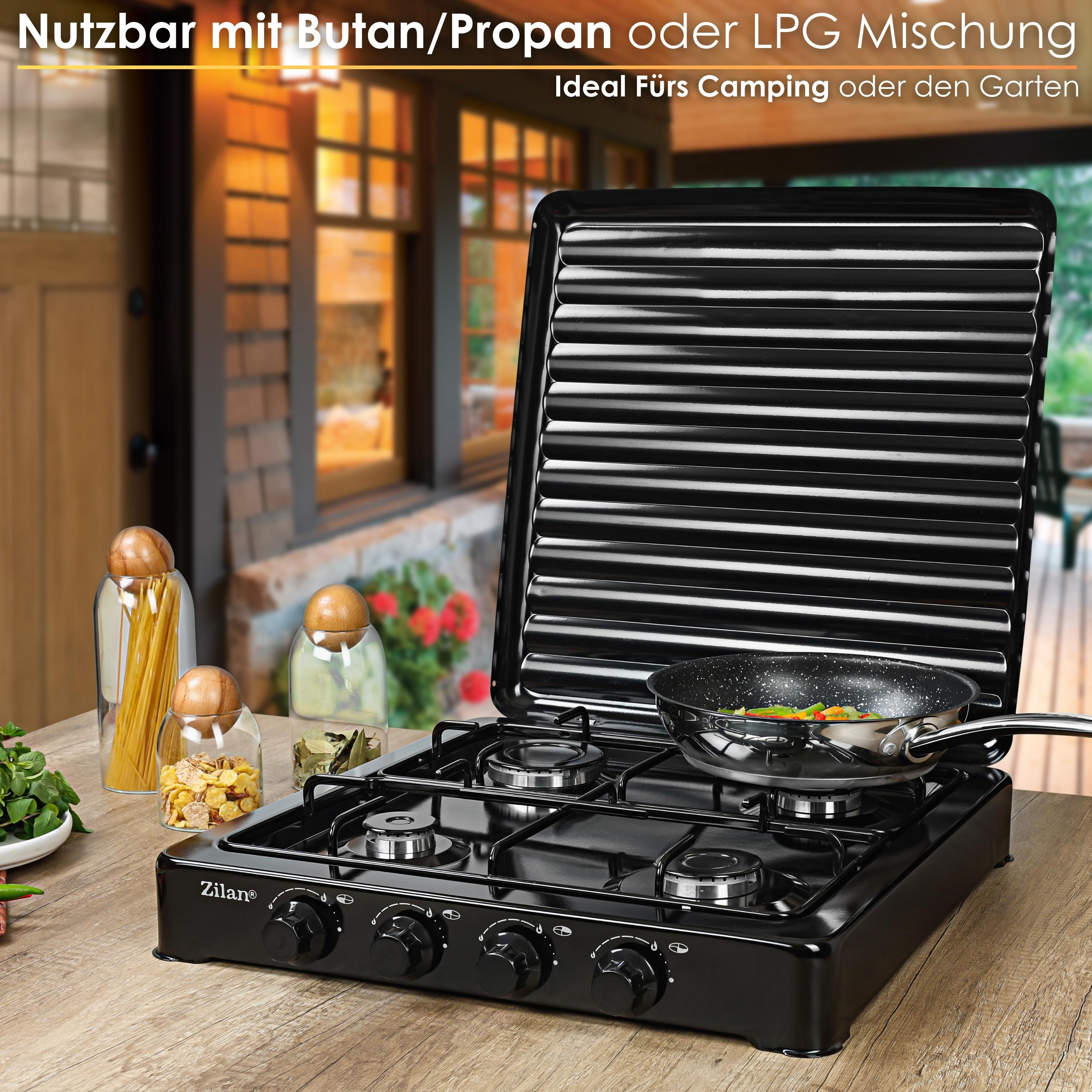 Czarna kuchenka gazowa Zilan z patelnią z warzywami. Słoiki z makaronem i płatkami na drewnianym stole.