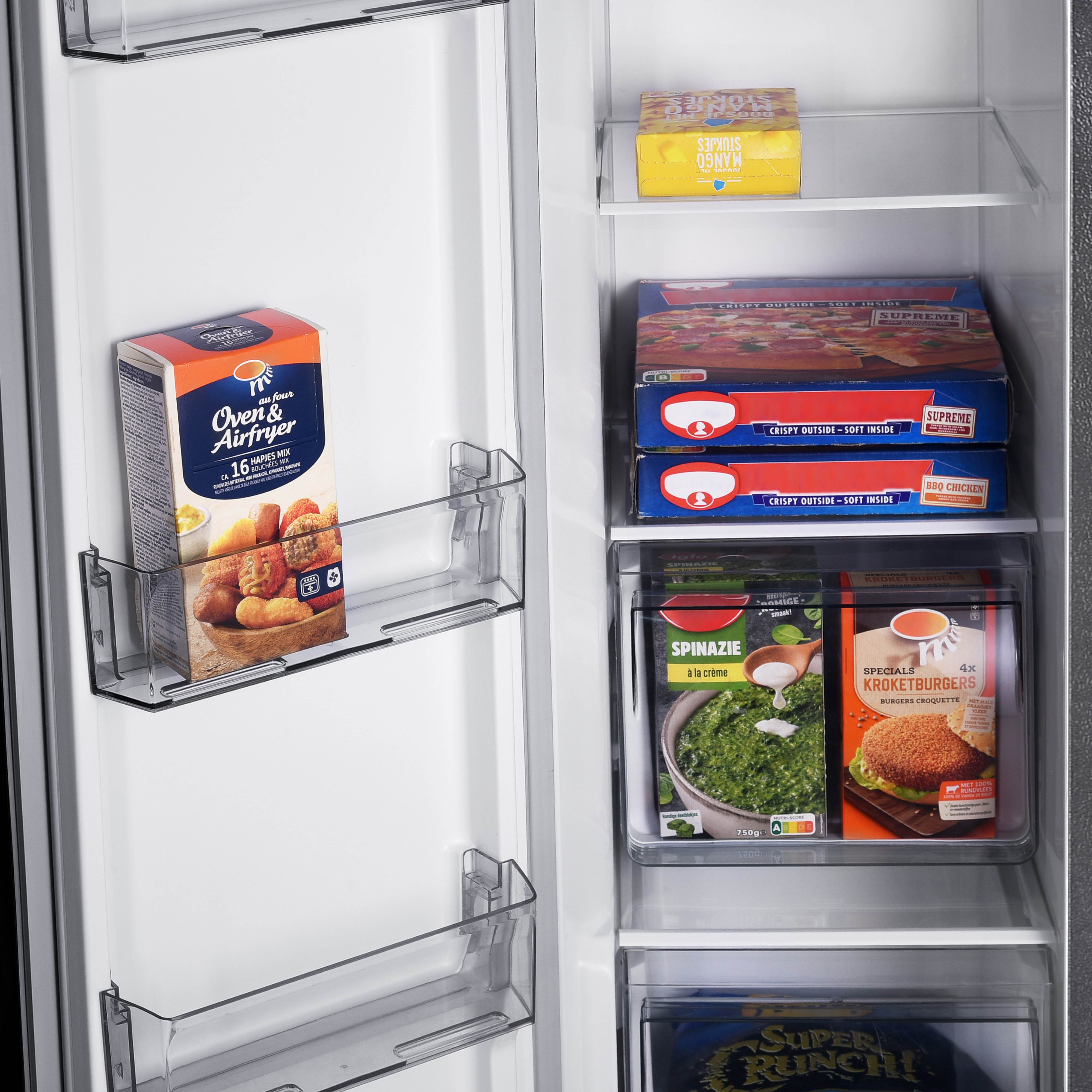 Open fridge with various frozen food items: pizza, spinach, croquettes, and a box of snacks. Clear storage shelves are visible.