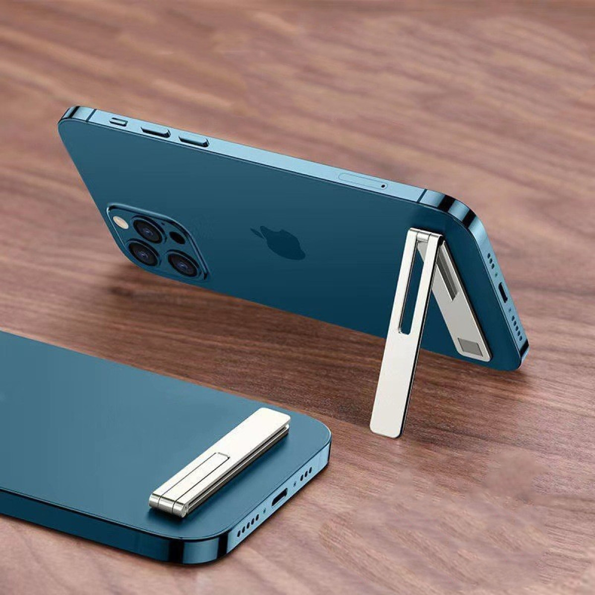 Dwa turkusowe smartfony na drewnianym stole. Jeden podparty srebrną podstawką, drugi leży płasko z dołączoną srebrną podstawką.