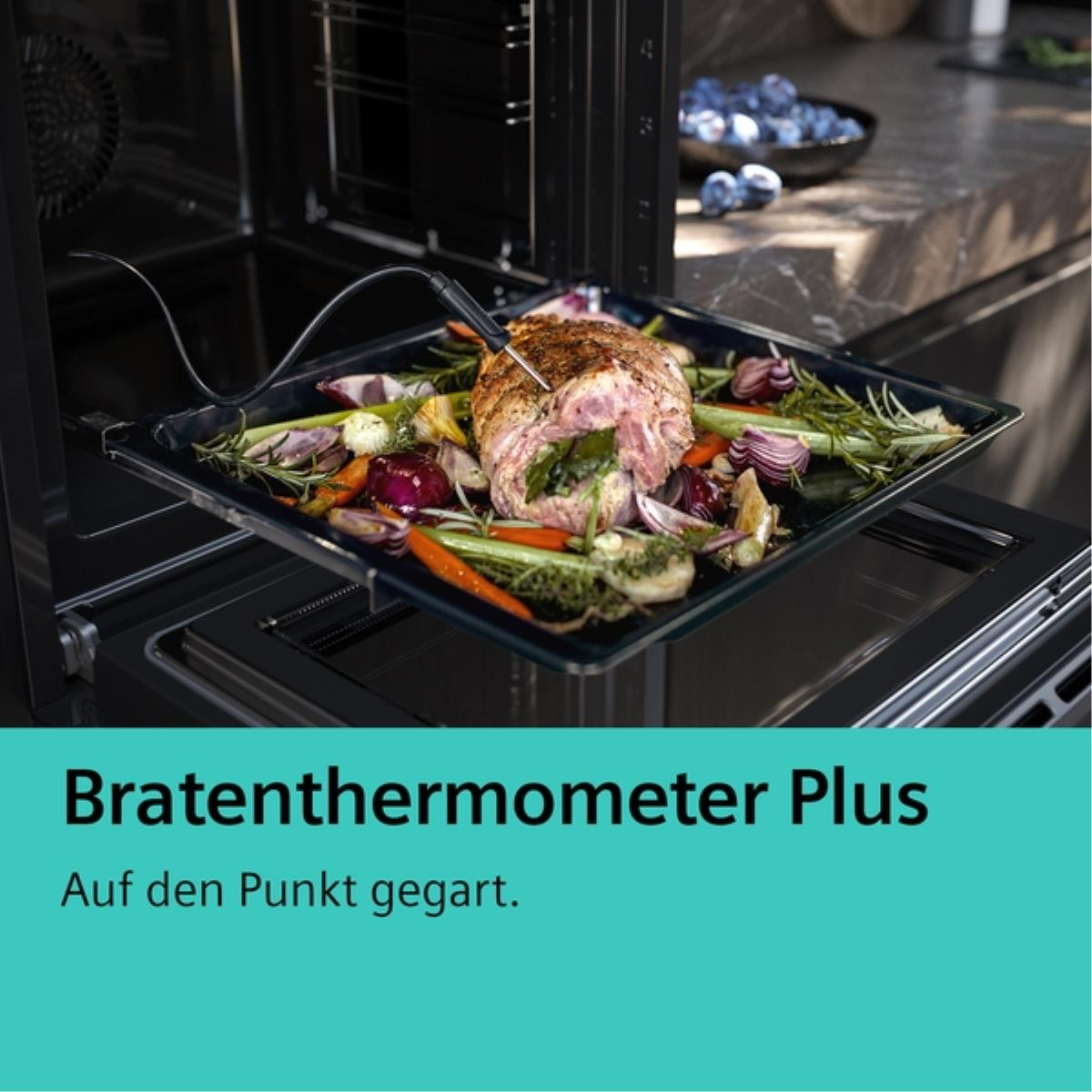 Een braadstuk met thermometer in een oven. Groenten omringen het vlees. De ovendeur is open.