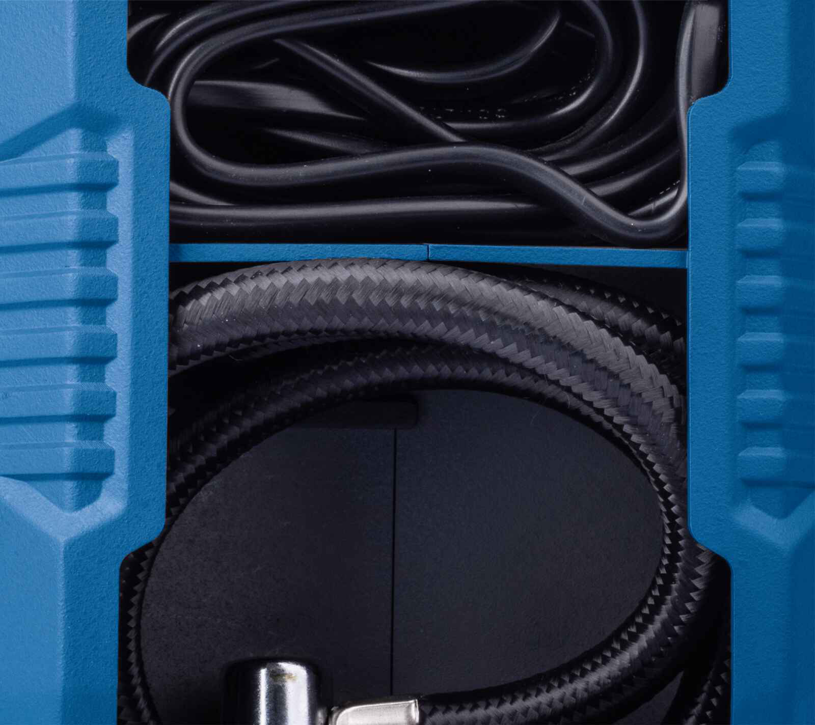 Primo piano di un contenitore blu che contiene cavi a spirale neri e un tubo intrecciato. Il contenitore è in ombra.
