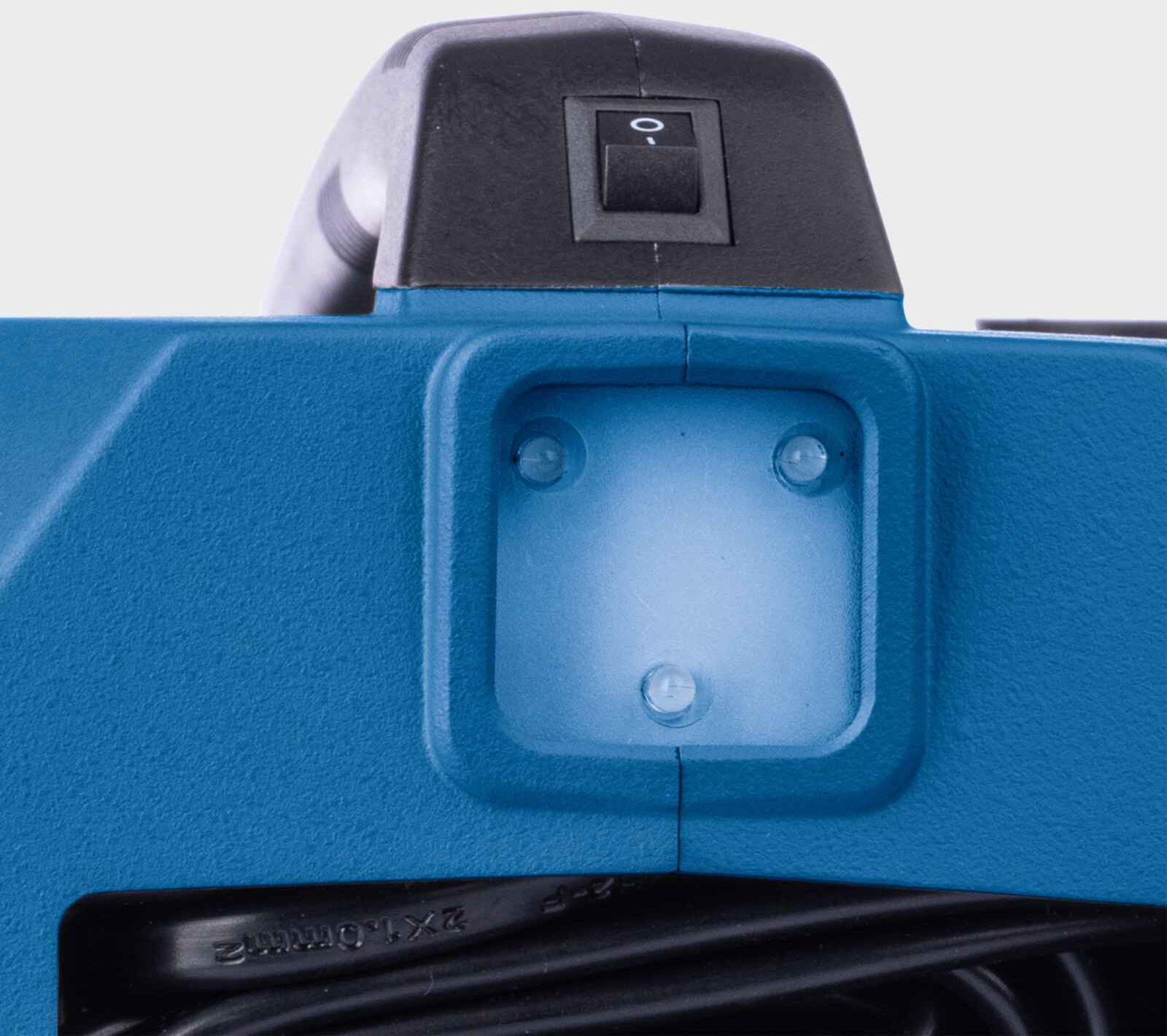 Primo piano di un utensile elettrico blu. Un interruttore nero è in alto e una luce al centro. Cavo nero in basso.