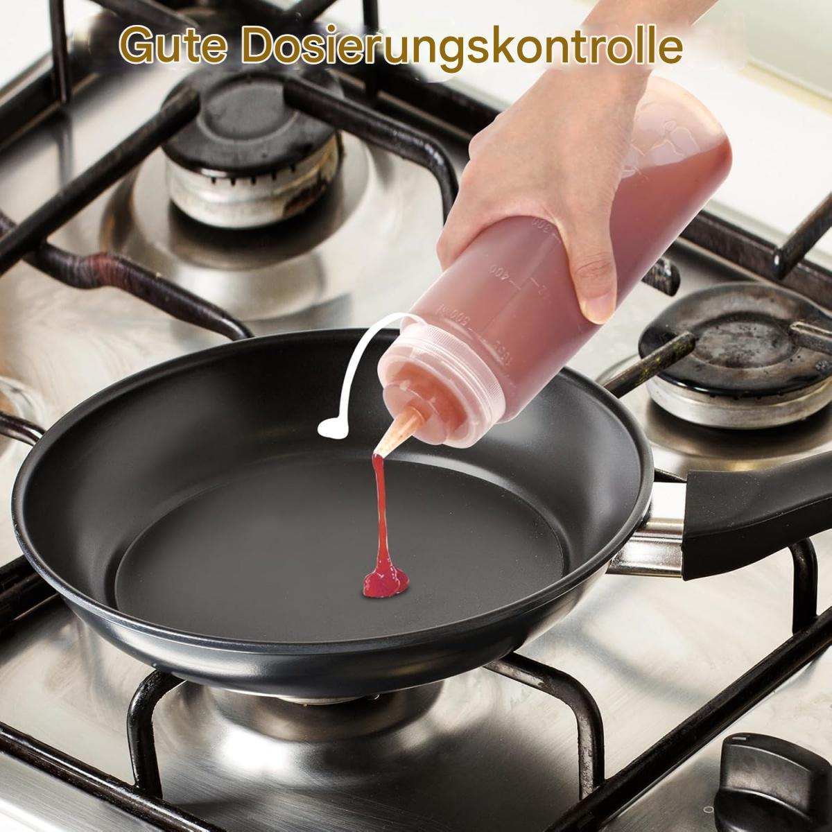 Eine Hand quetscht eine Soßenflasche und gibt rote Soße in eine schwarze Pfanne auf einem Gasherd ab.