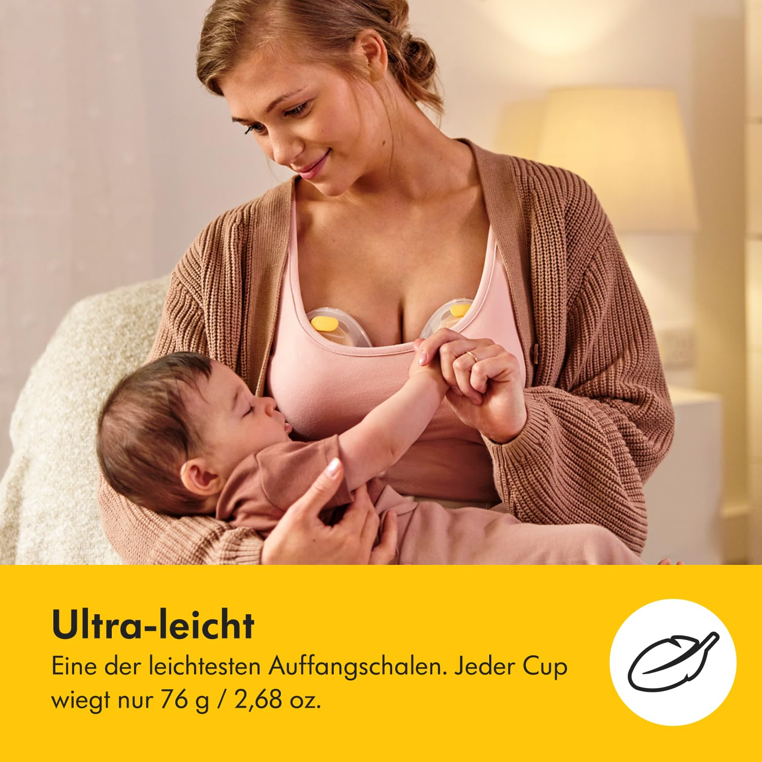 Mutter hält Baby. Mutter trägt rosa Top und braunen Cardigan. Brustpumpen sind sichtbar. Text: Ultra-leicht, 76 g / 2,68 oz.