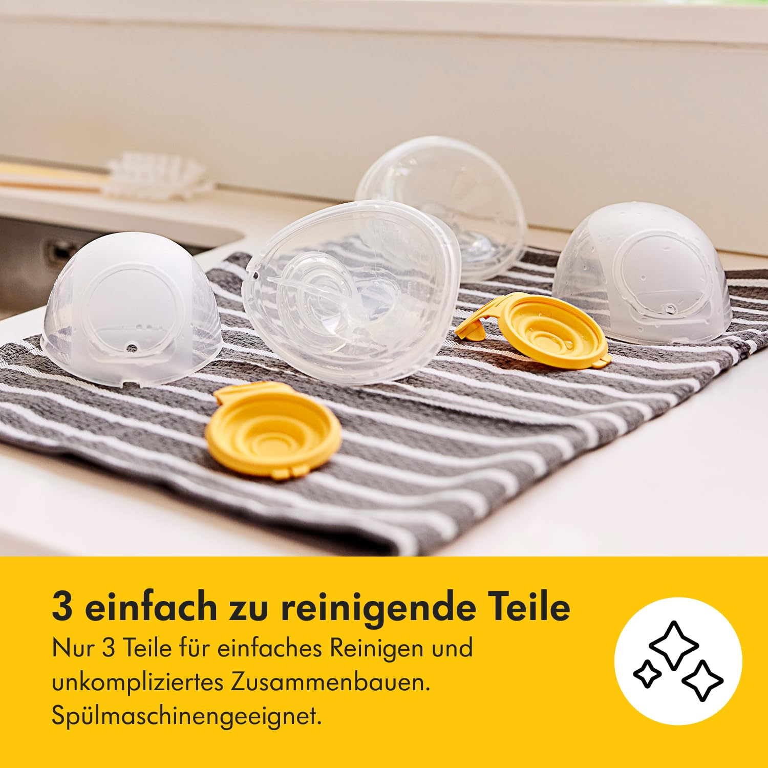 Brustpumpenteile auf einem gestreiften Handtuch. Enthält transparente Plastikteile und gelbe Kappen. Der Hintergrund ist weiß.