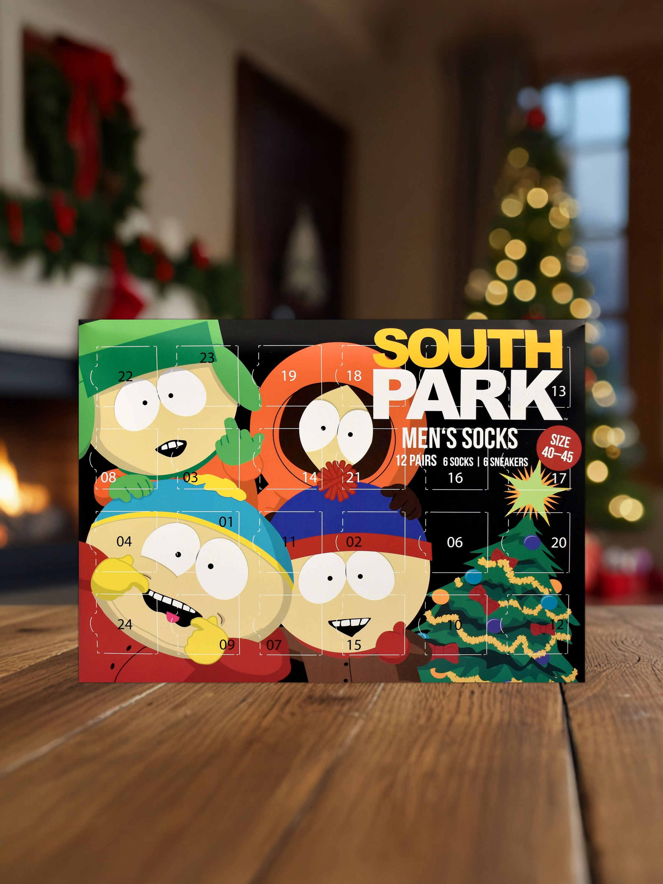 Ein Adventskalender mit South Park-Figuren. Er steht auf einem Holztisch, im Hintergrund ein Weihnachtsbaum und ein Kamin.