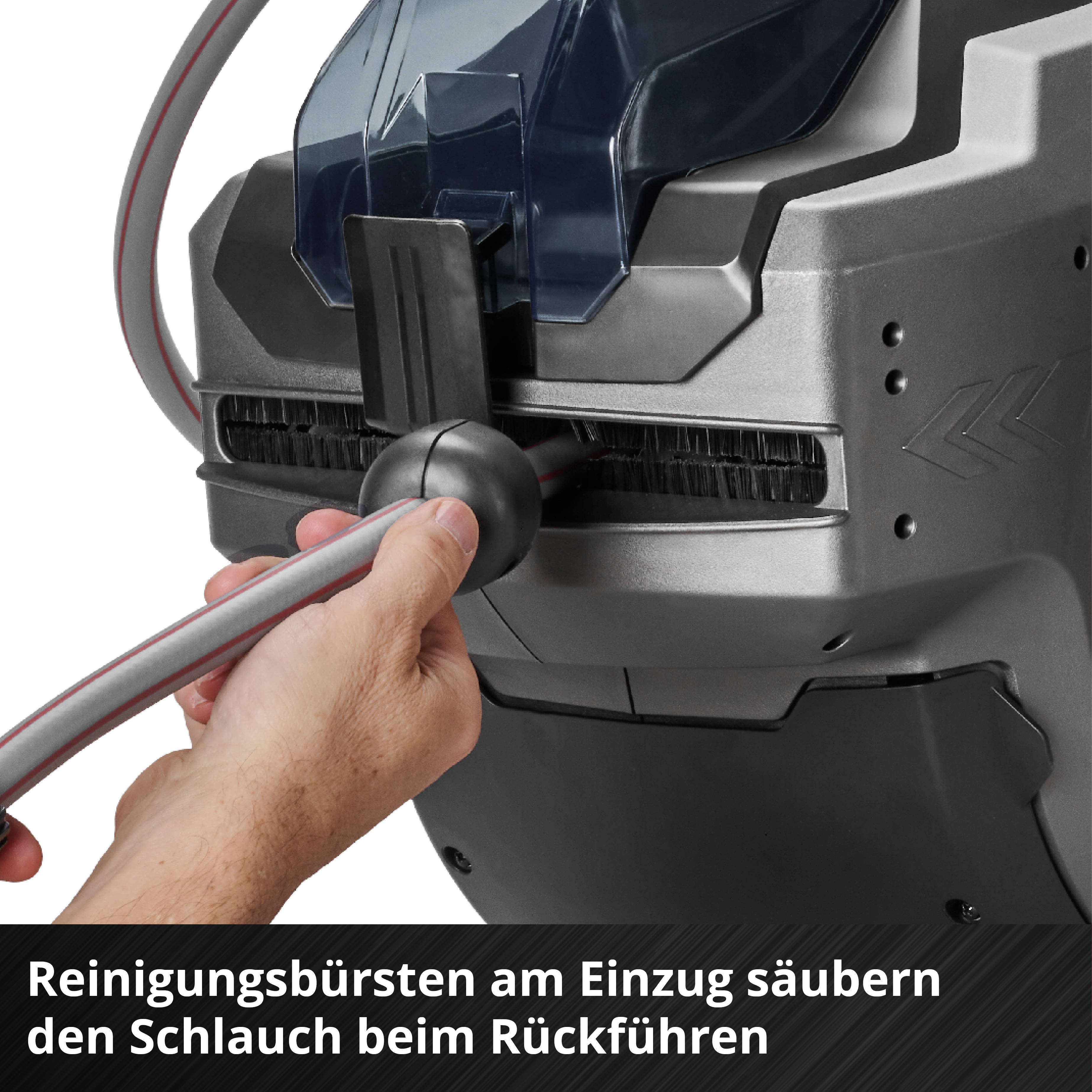 Eine Hand hält einen Schlauch an einer Maschine mit Reinigungsbürsten. Die Maschine ist grau und schwarz. Der Schlauch ist grau mit rotem Streifen.