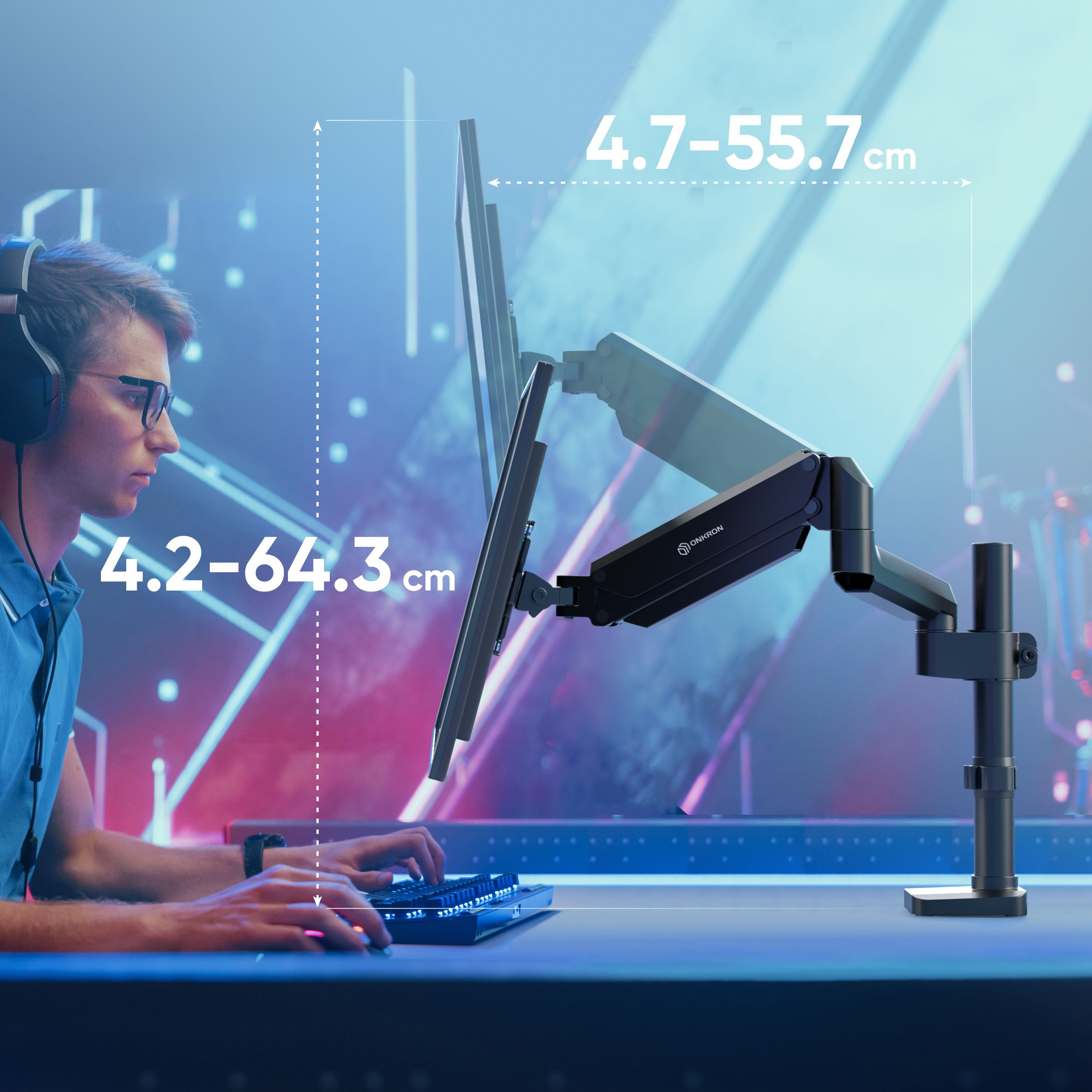 Mężczyzna w okularach i słuchawkach siedzi przy biurku z monitorem. Ramię trzyma monitor. Wyświetlane są wymiary.