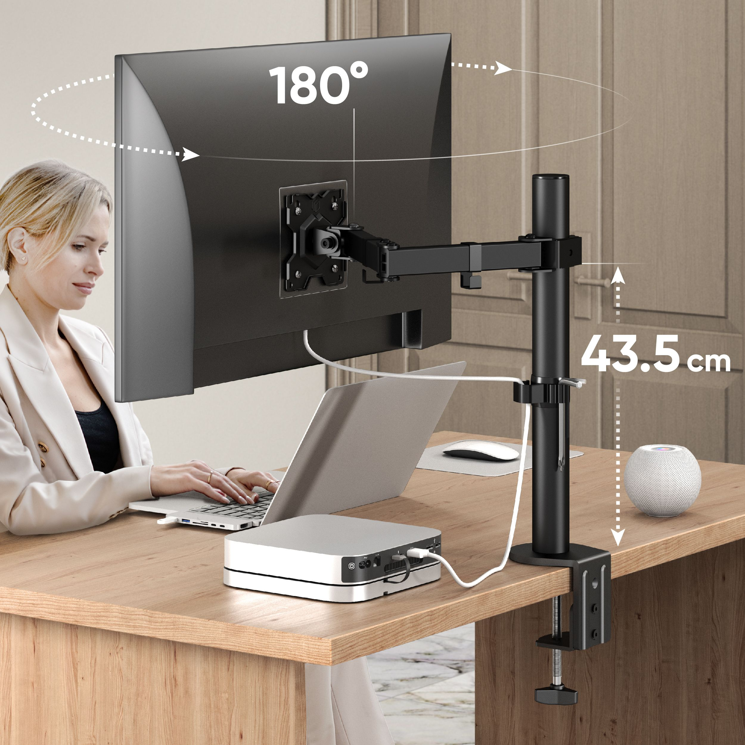 Une femme est assise à un bureau avec un moniteur et un ordinateur portable. Un bras de moniteur noir est installé.
