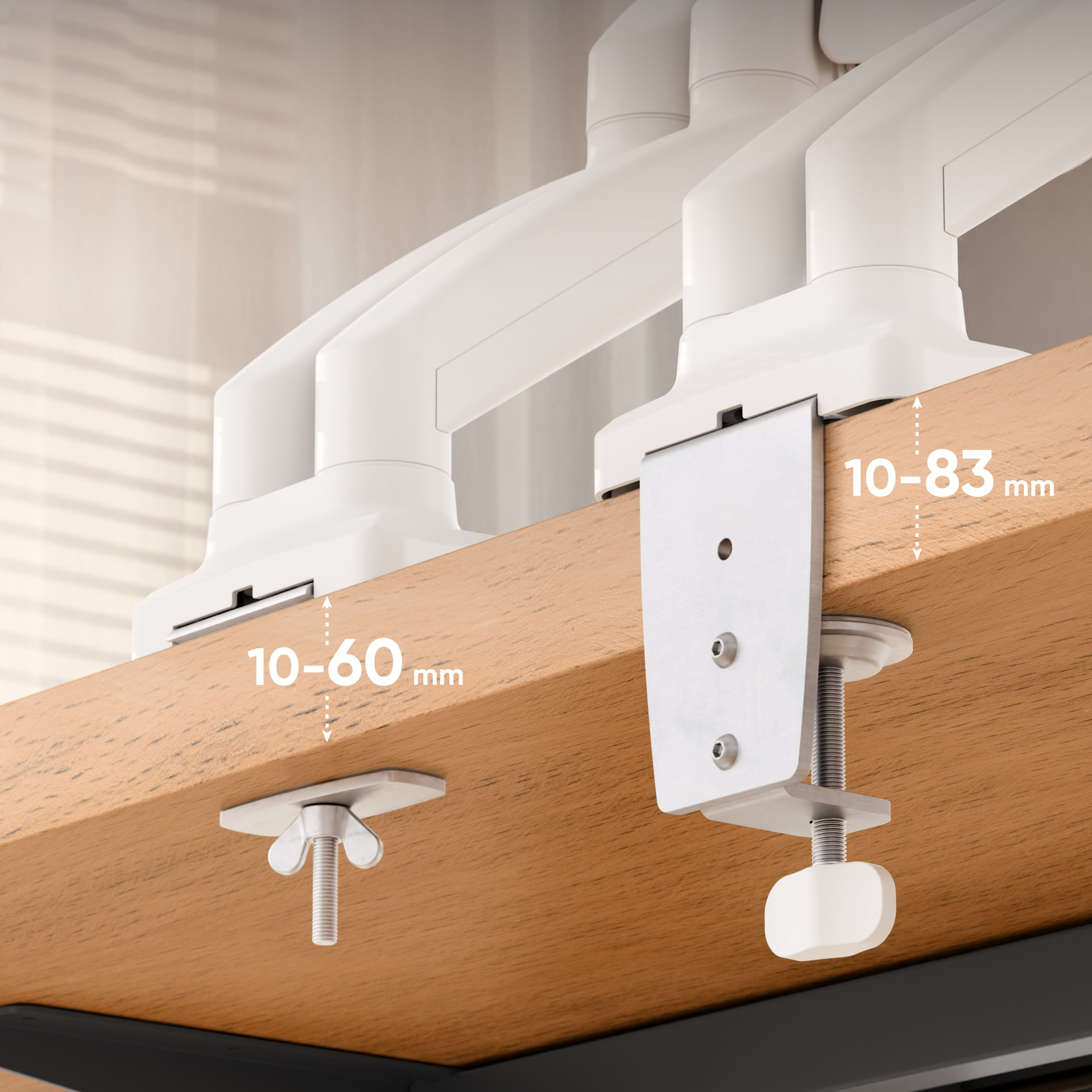 Zbliżenie zacisku biurkowego do ramienia monitora. Pokazuje zacisk i mechanizm śrubowy. Tło jest jasne.