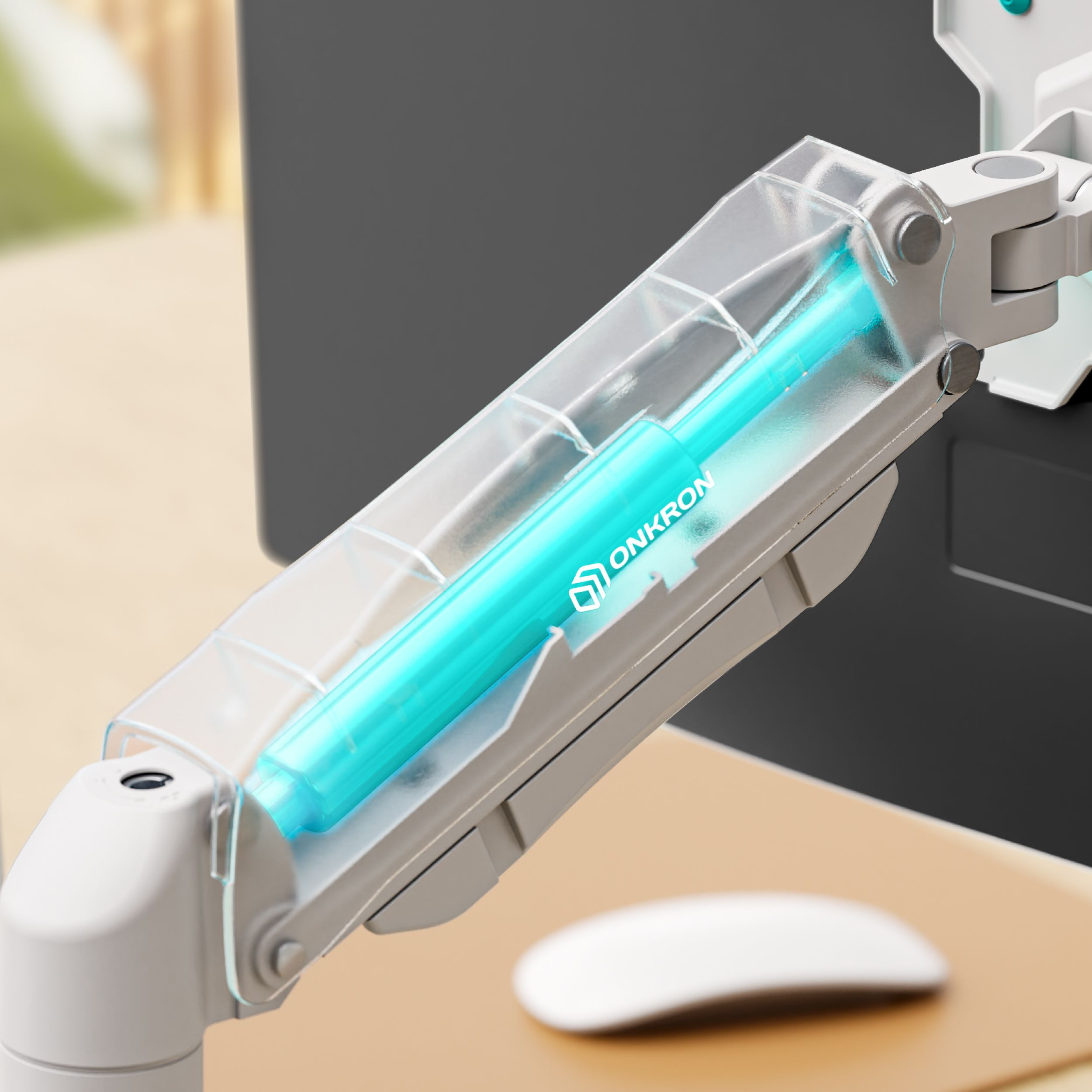 Ramię monitora z turkusowym cylindrem w przezroczystej obudowie, mysz komputerowa i część monitora są widoczne.