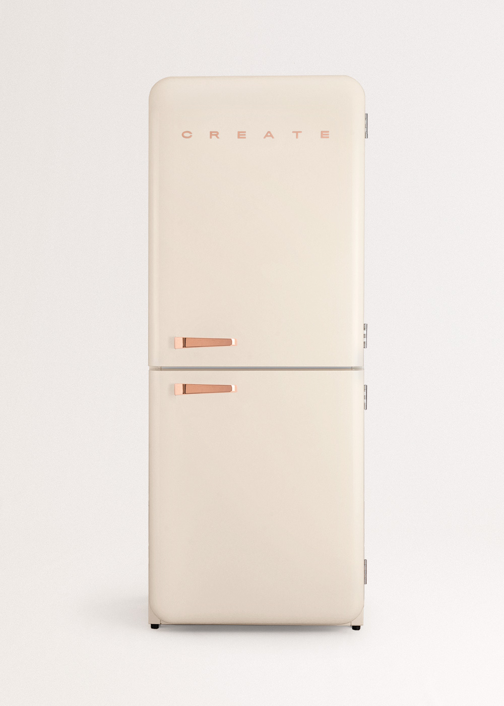 Refrigerador retro crema con manijas de oro rosa y la palabra 'CREATE'. Tiene dos puertas sobre un fondo blanco.