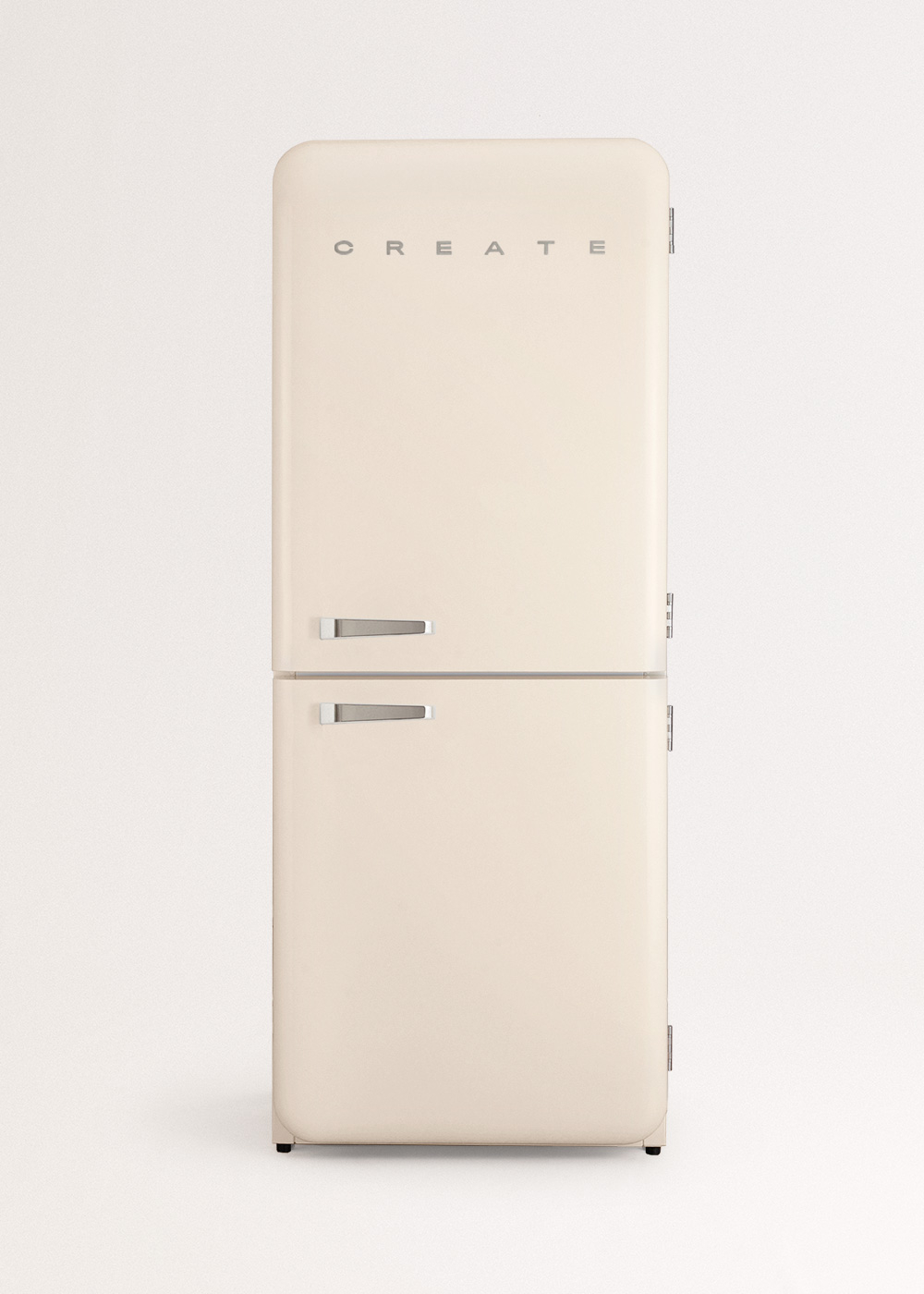 Un refrigerador retro color crema con manijas plateadas. La palabra CREATE está en la parte superior. Sobre un fondo blanco liso.