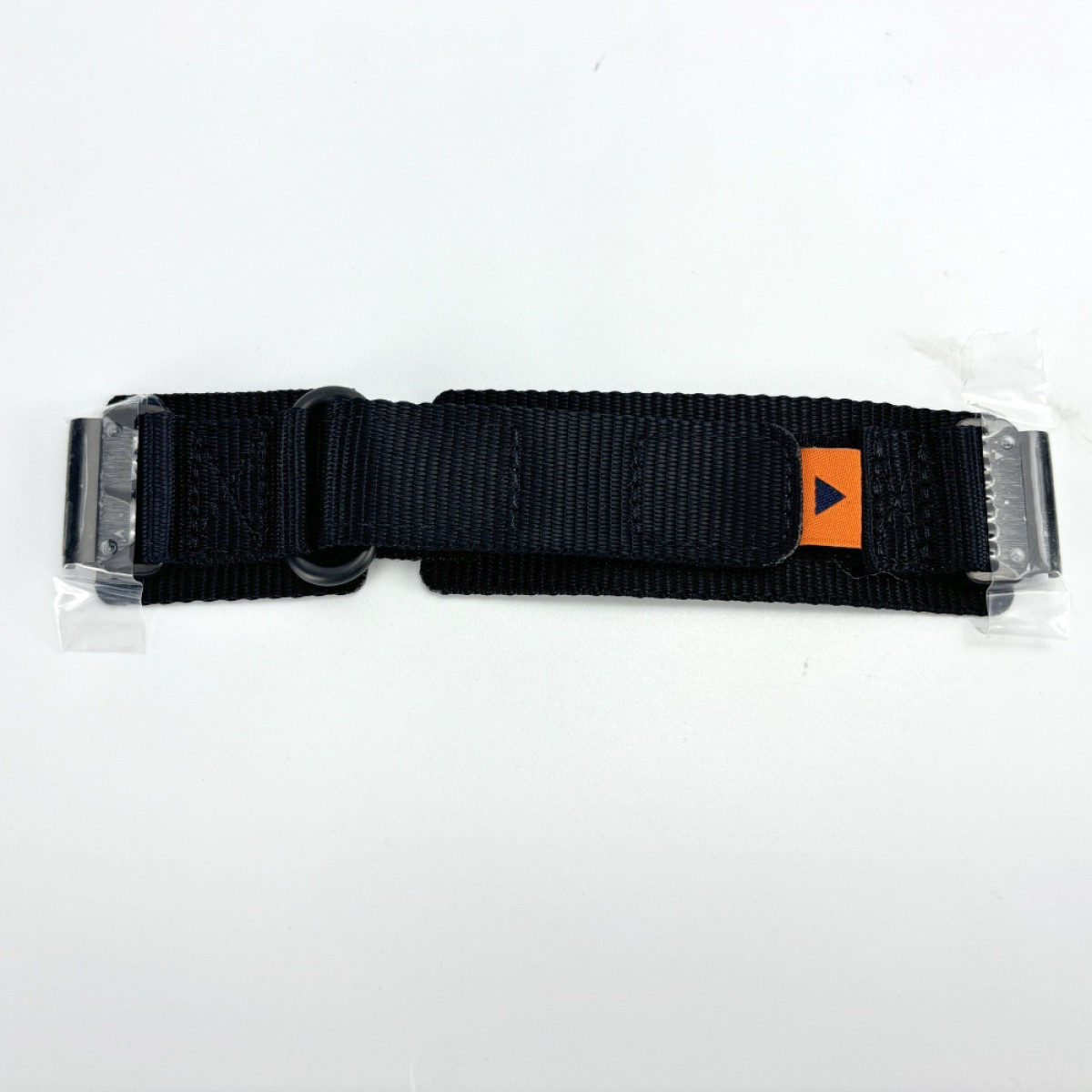 Ein schwarzes Uhrenarmband liegt horizontal auf einer weißen Oberfläche. Es hat eine Metallschnalle und ein orangefarbenes Etikett mit einem blauen Pfeil.