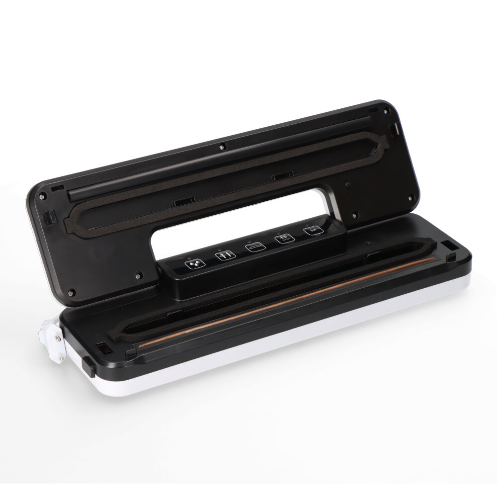 Czarno-biała zgrzewarka próżniowa jest otwarta. Górna część jest czarna, odsłaniając czarne wnętrze z przyciskami. Dolna część jest biała.