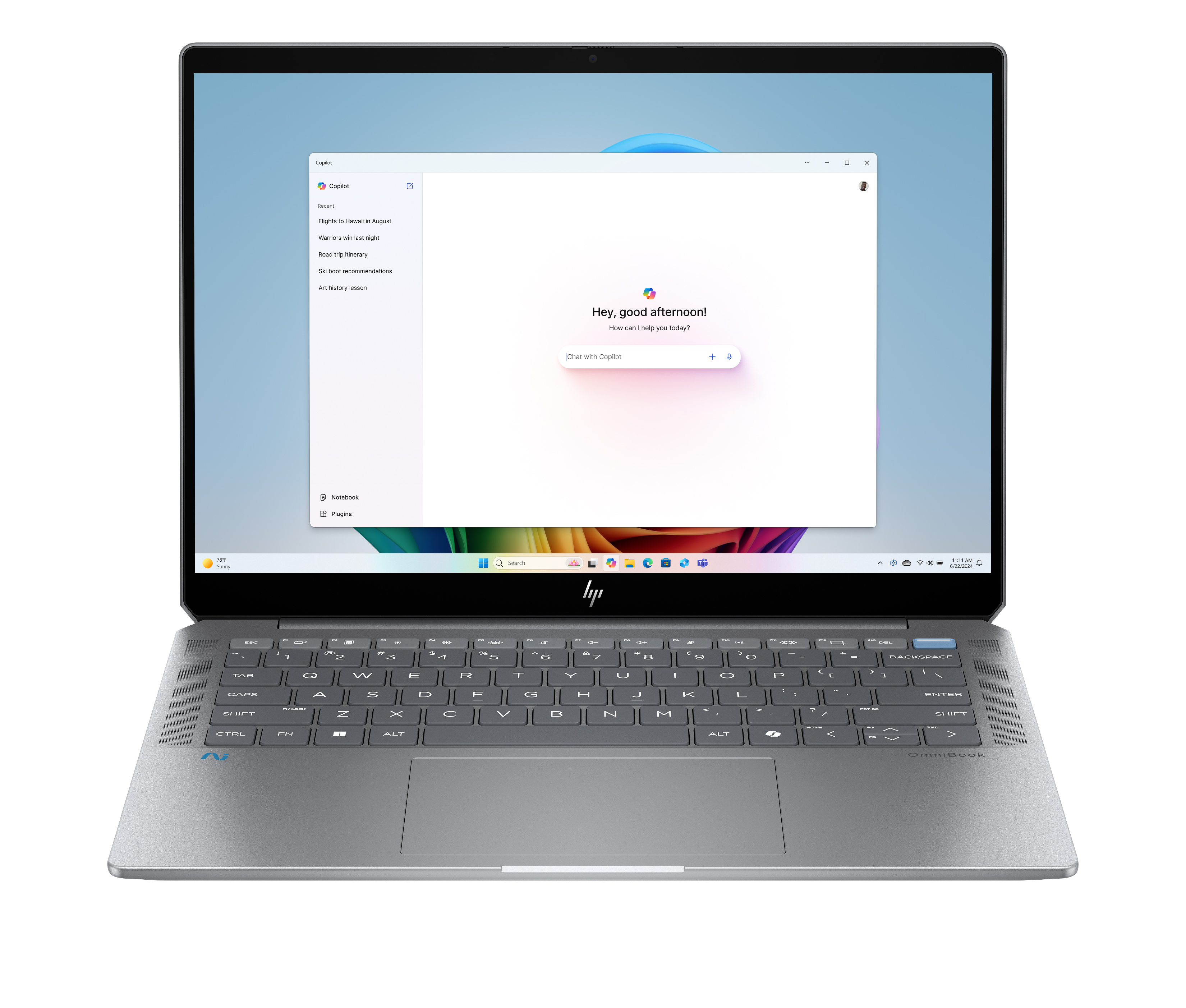 Il laptop argentato mostra l'interfaccia Copilot. È una giornata di sole. La tastiera è in basso.