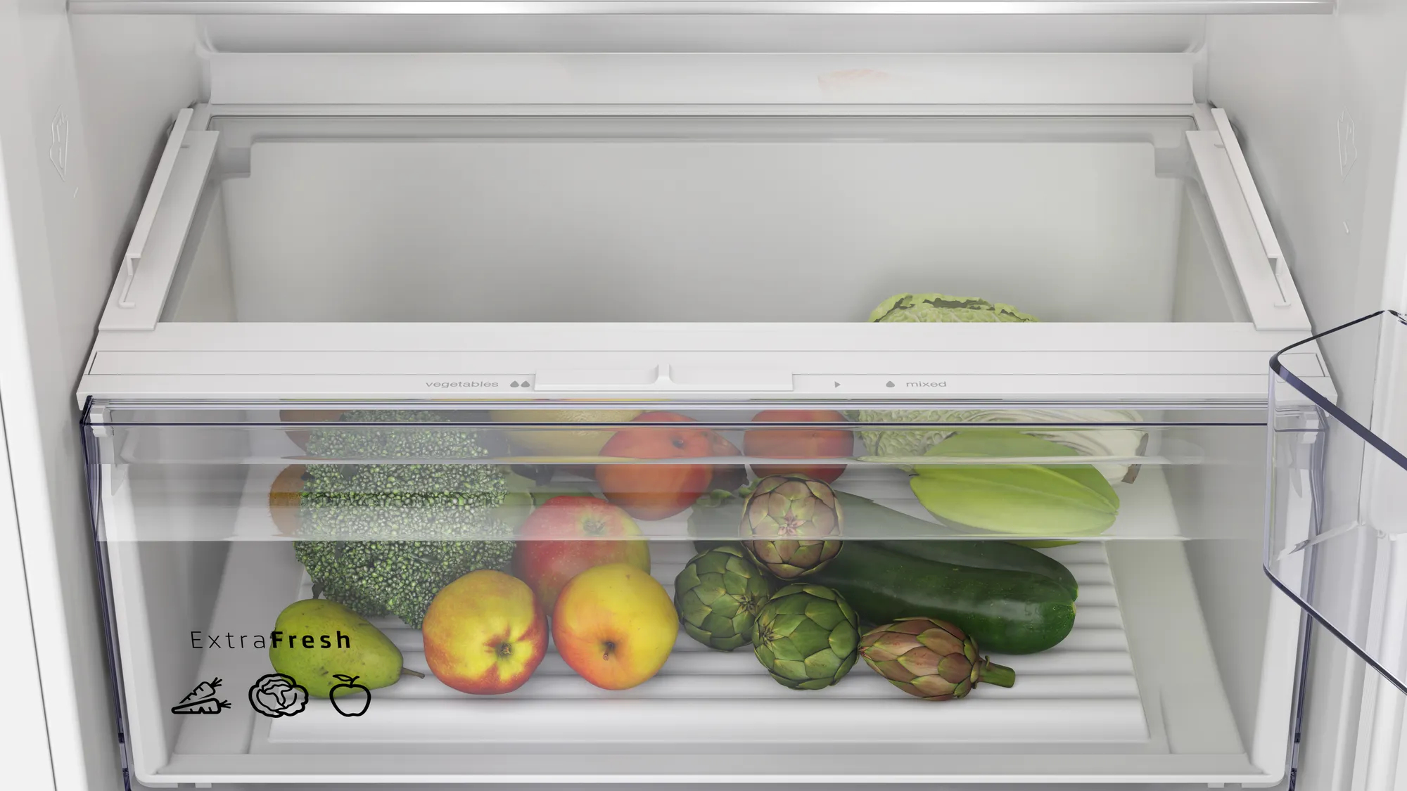 Dentro de un refrigerador, se almacenan verduras y frutas. Se ven manzanas, alcachofas, calabacín y brócoli en el cajón.