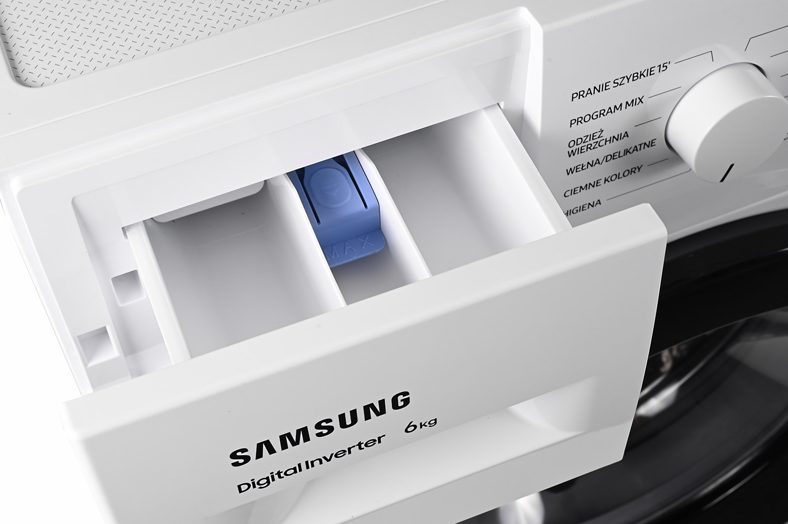 Zbliżenie białej pralki z otwartą szufladą na detergent. Widoczne logo Samsung. Wymienione są opcje programu prania.