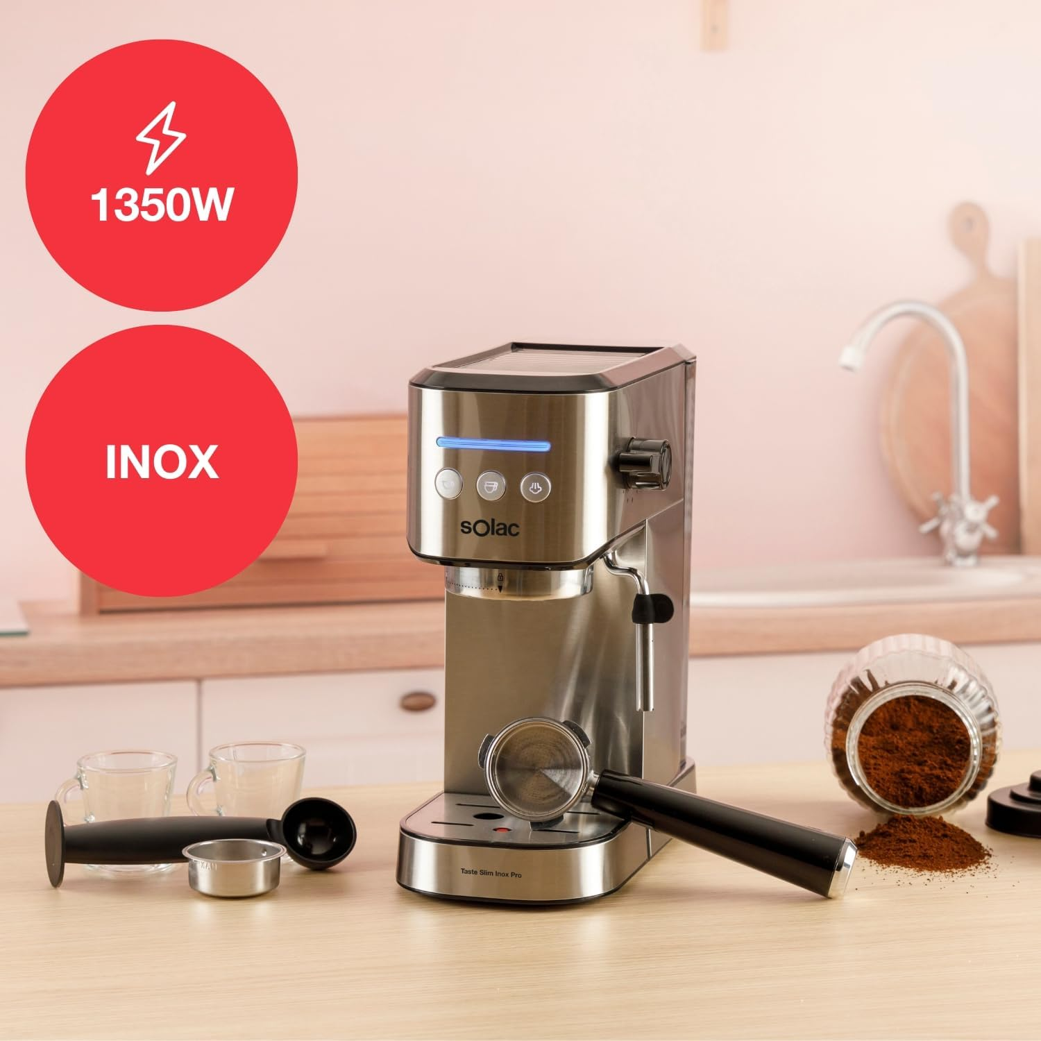 Una cafetera espresso de acero inoxidable con accesorios se encuentra sobre una mesa de madera. Círculos rojos con texto están encima.