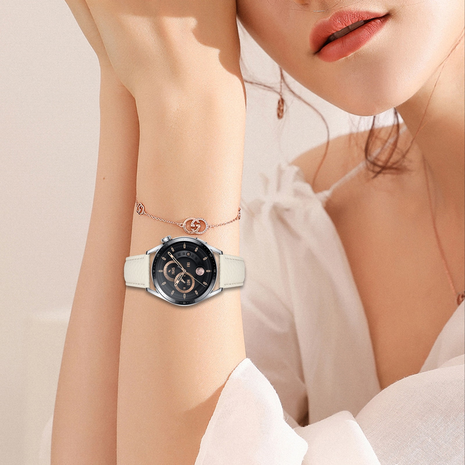 Braccio di donna con orologio e braccialetto. L'orologio è argentato con quadrante nero e cinturino bianco. Labbra visibili.