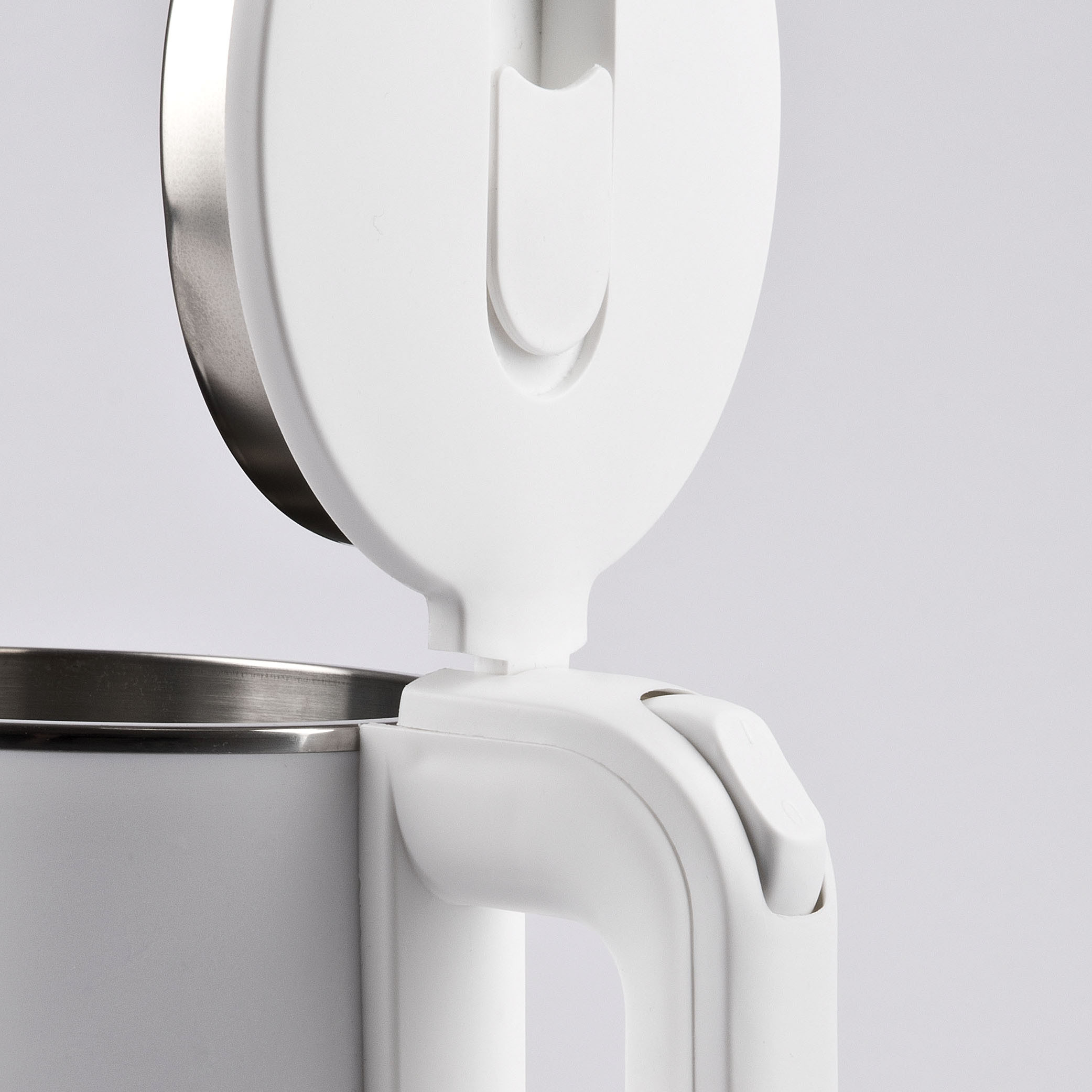 Zbliżenie białego czajnika elektrycznego z otwartą pokrywą. Czajnik jest biały ze srebrnymi akcentami, tło jest białe.