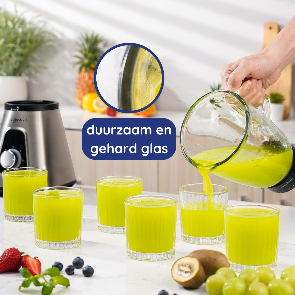 Une main verse du jus vert d'une carafe dans des verres. Des fruits comme l'ananas, le kiwi, les raisins et les baies sont sur la table.