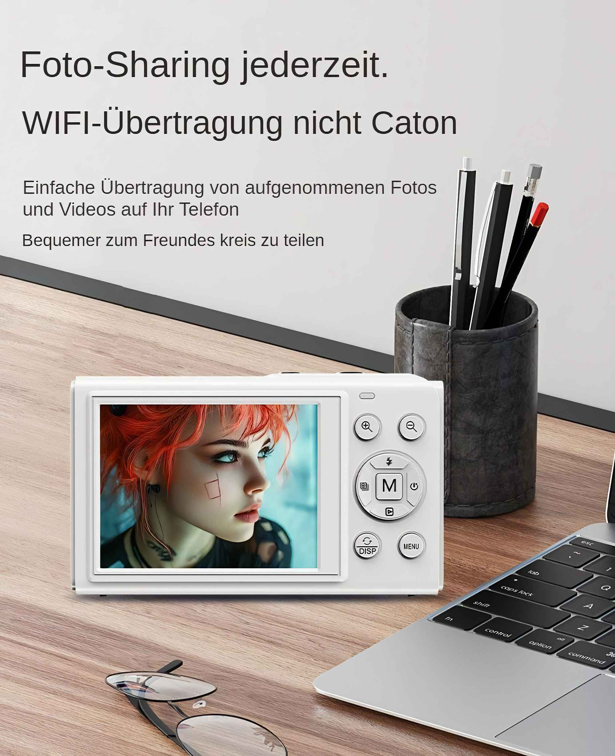Eine weiße Kamera zeigt eine Frau mit roten Haaren. Stifte sind in einem Becher. Ein Laptop und eine Brille liegen auf Holz.