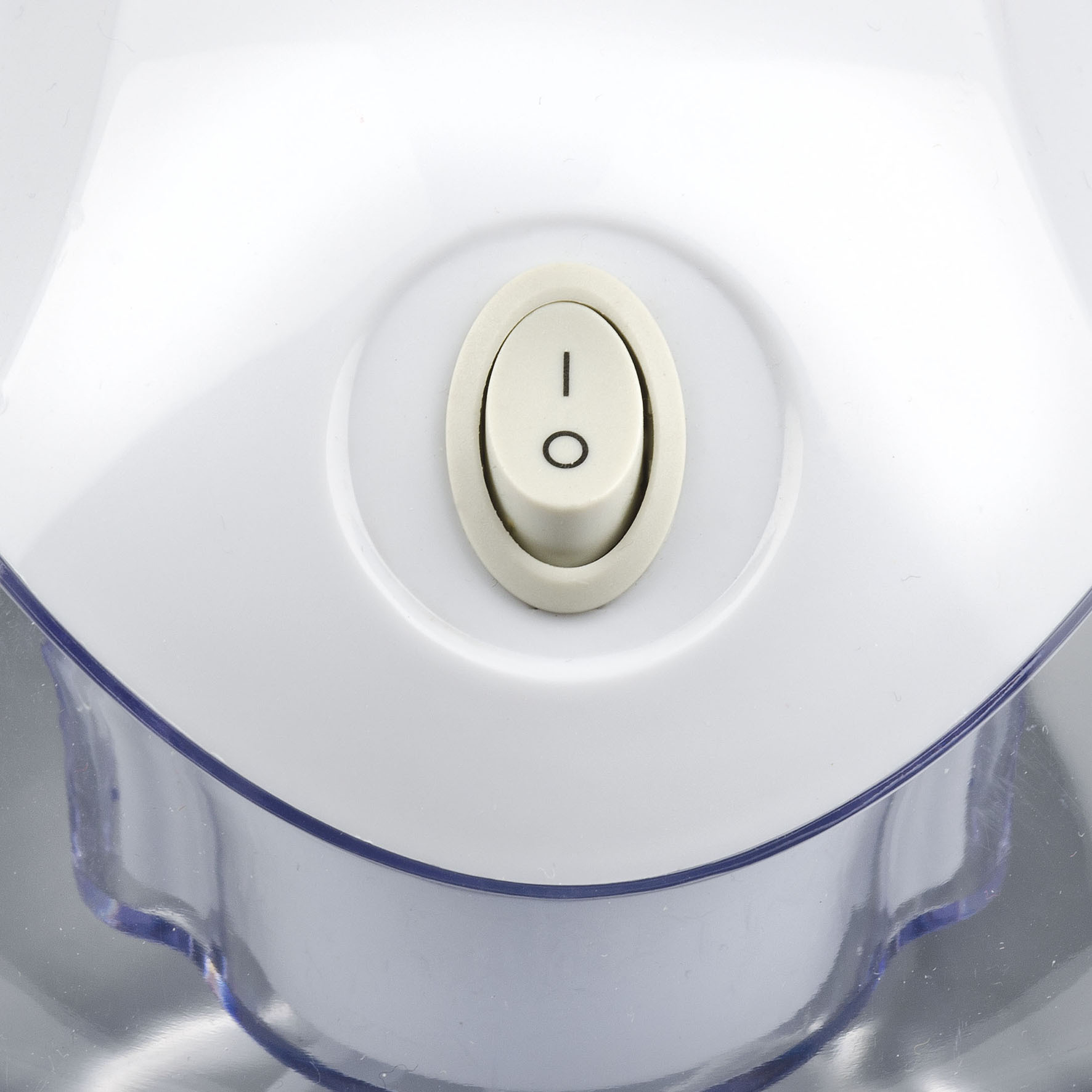 Zbliżenie białego włącznika zasilania z symbolem włączenia/wyłączenia. Przełącznik jest beżowy, na białej plastikowej powierzchni.