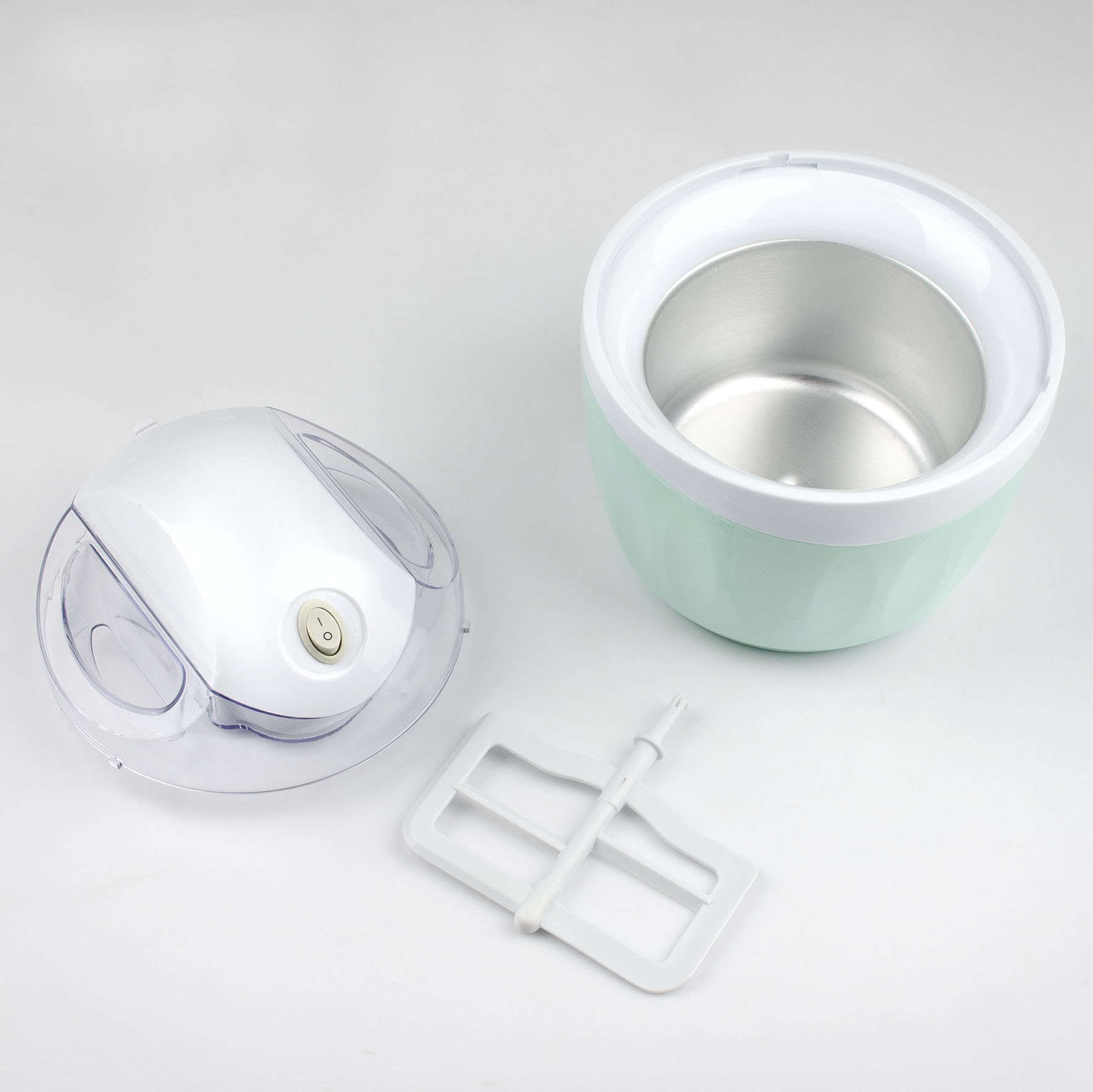 Maszyna do lodów z komponentami: misą, pokrywą i mieszadłem na białej powierzchni. Maszyna jest miętowo-zielona i biała.