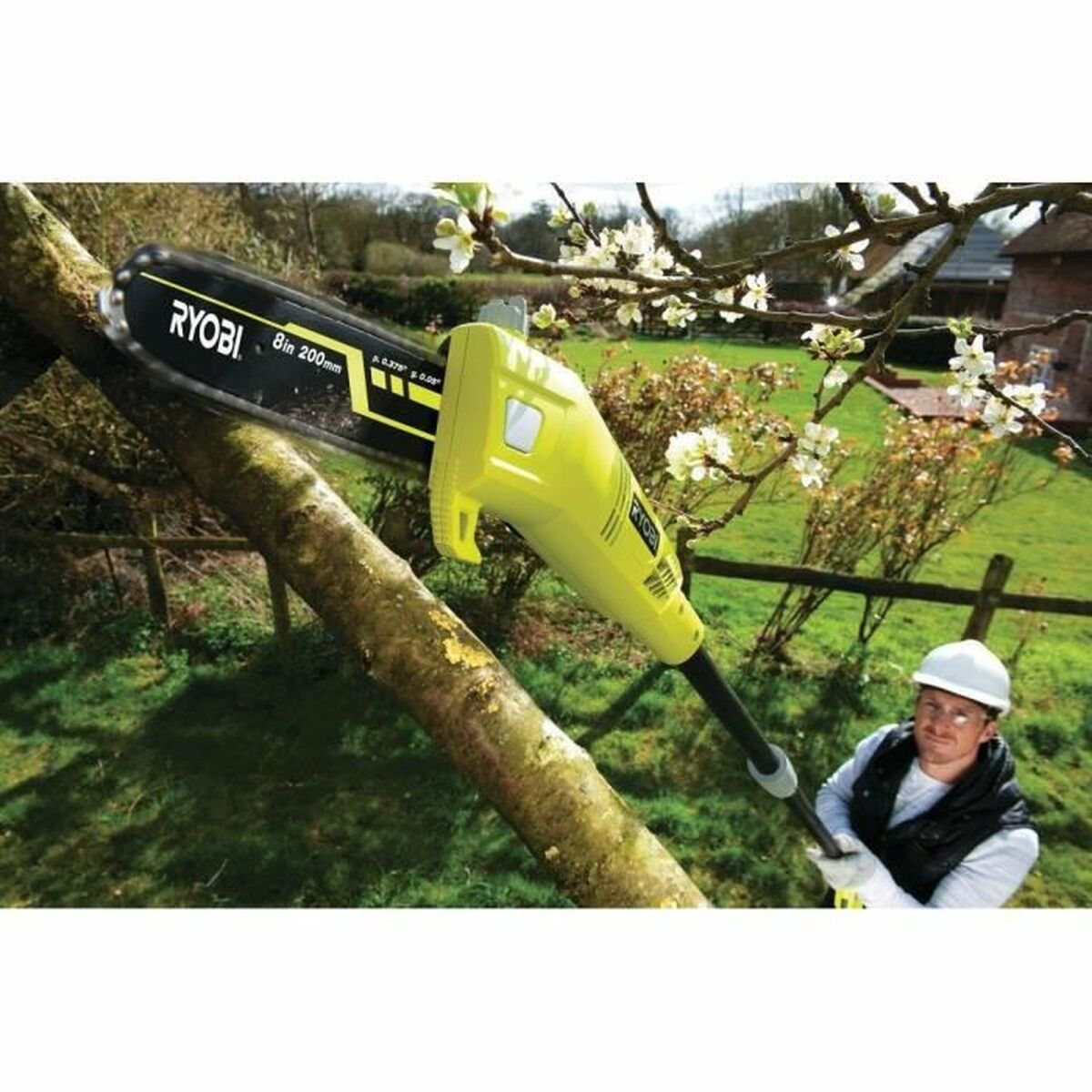 Ein Mann benutzt eine gelbe Ryobi-Kettensäge an einem Ast. Er trägt einen Helm und eine Weste. Grünes Gras und Blumen sind im Hintergrund.