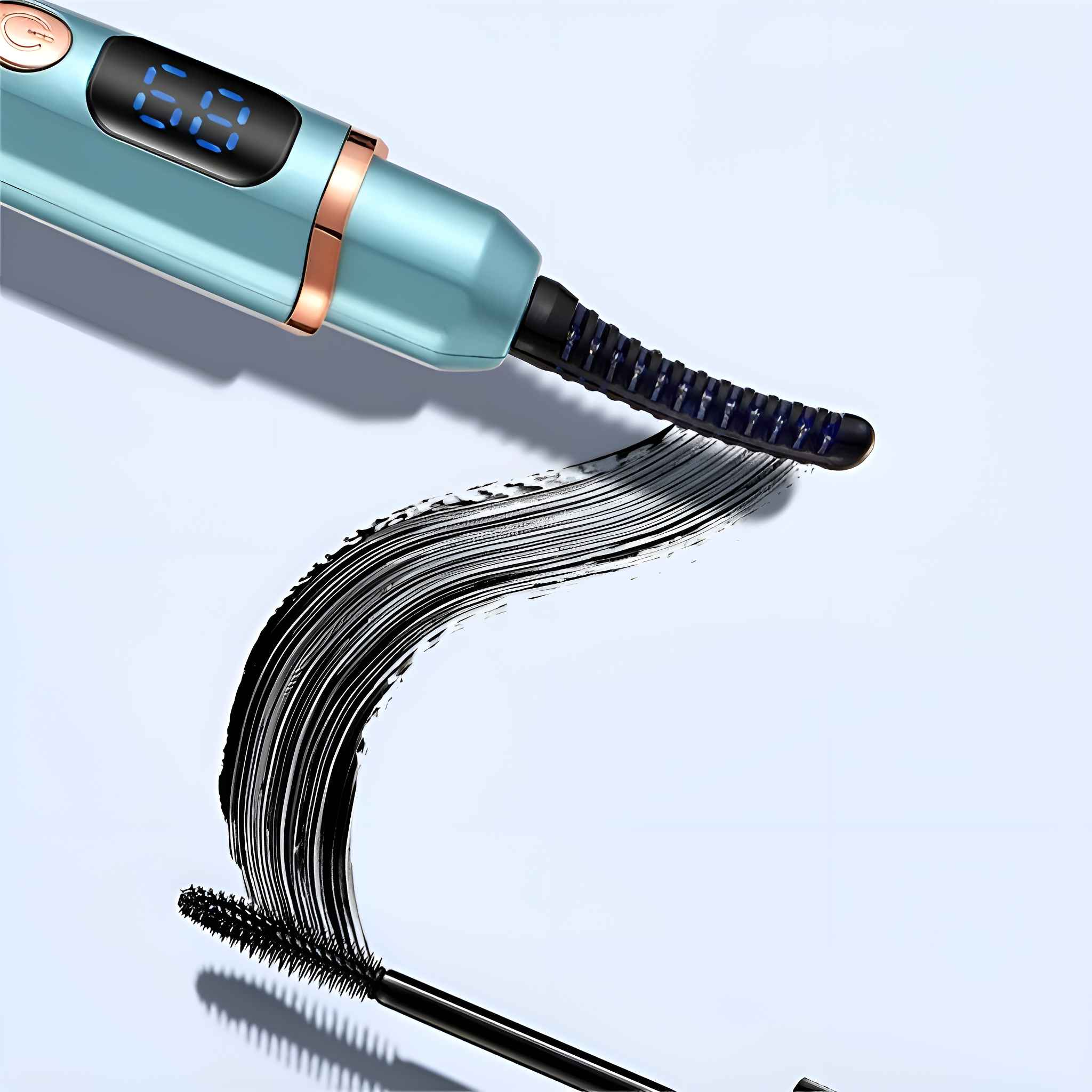 Ein Wimpernzange mit einer schwarzen Mascarabürste. Der Lockenwickler ist teal und gold. Die Mascara hat dicke schwarze Striche.