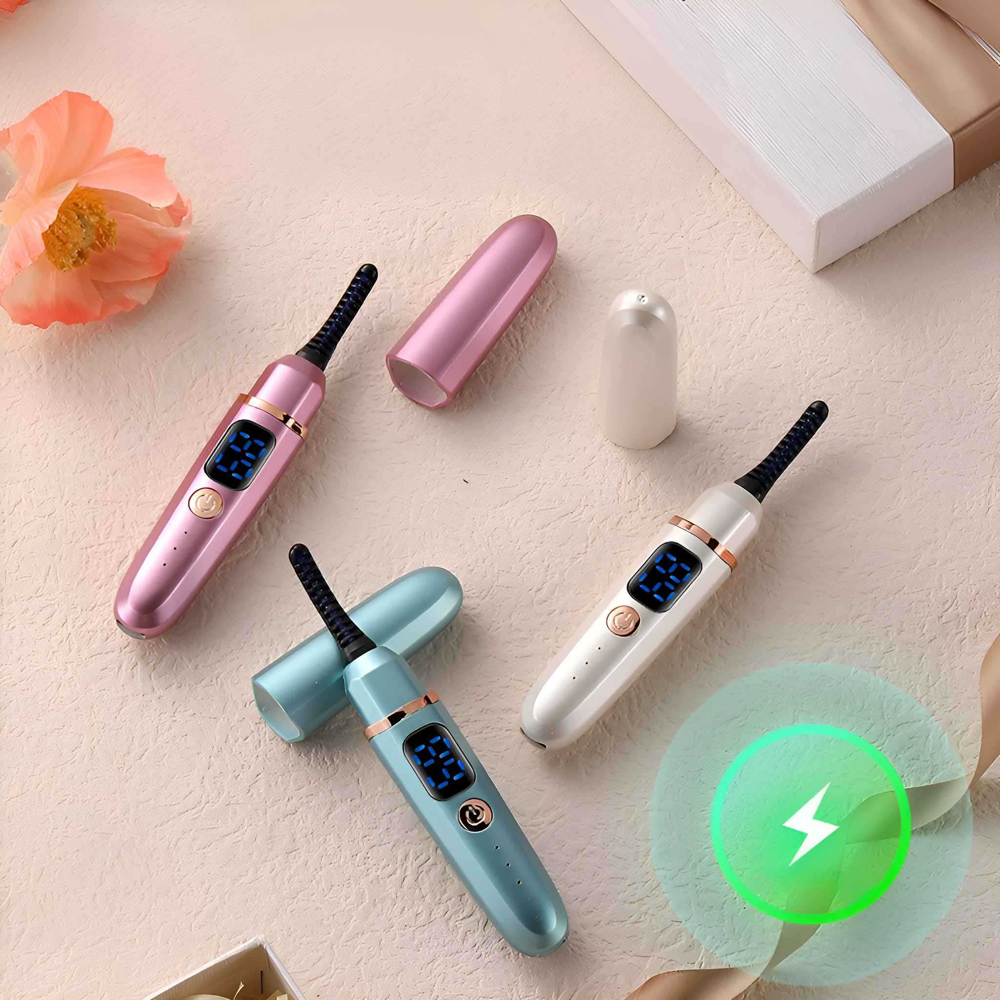 Drei Wimpernzangen in Rosa, Blau und Weiß mit Digitalanzeigen. Eine Blume, eine Geschenkbox und ein Ladesymbol sind sichtbar.