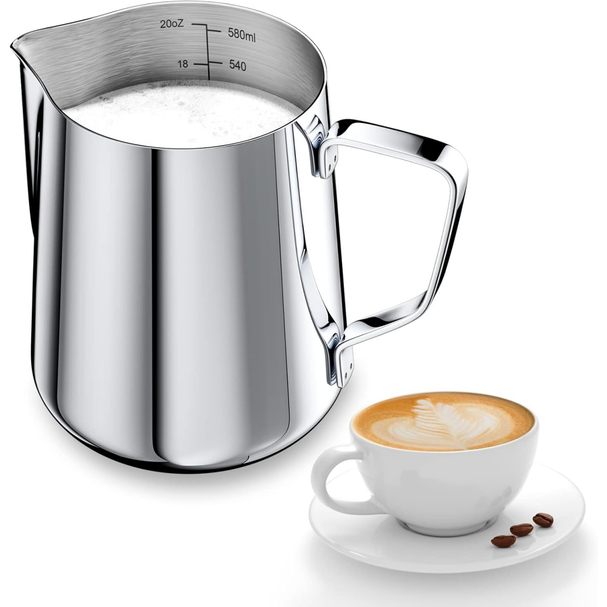 Ein Edelstahl-Milchaufschäumer mit Milch, eine Tasse Latte und Kaffeebohnen auf einer weißen Oberfläche.