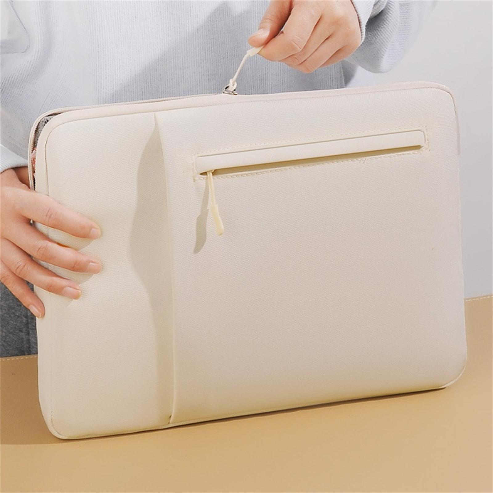 Eine Person hält eine cremefarbene Laptoptasche mit Reißverschluss. Der Hintergrund ist ein hellgrauer Pullover und eine beige Oberfläche.