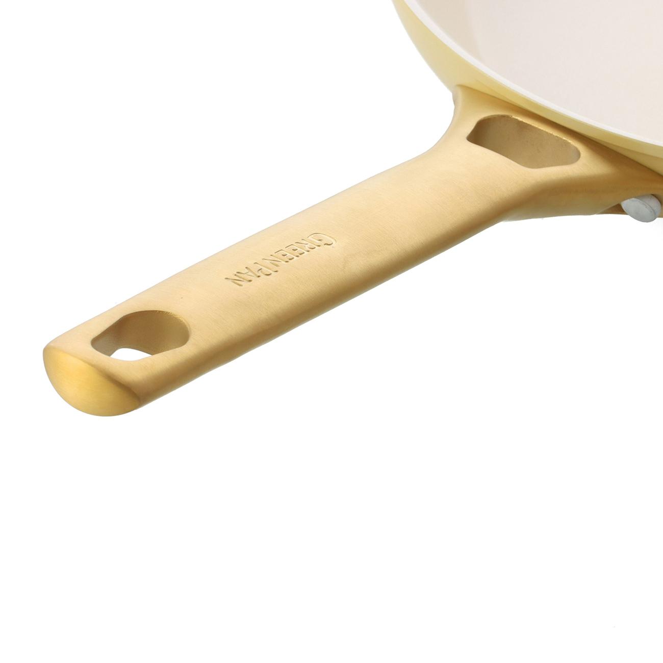 Nahaufnahme eines goldfarbenen Bratpfannenstiels mit der Marke 'GREENPAN'. Der Pfannenkörper ist cremefarben. Weißer Hintergrund.