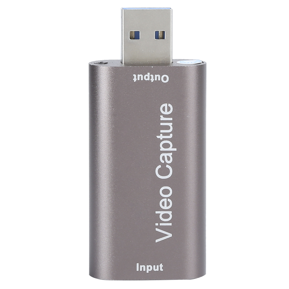 Ein silbernes und graues Videoaufnahmegerät. Es hat einen USB-Anschluss oben und trägt die Aufschrift 'Video Capture' und 'Input'.