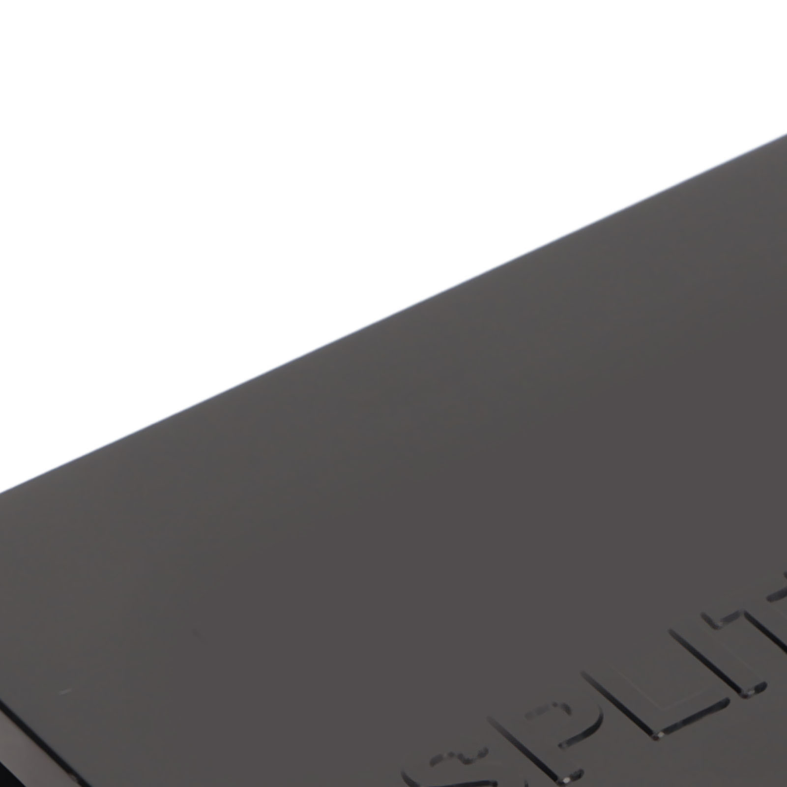 Schräge Ansicht einer dunklen, glänzenden Oberfläche mit geätzten Buchstaben, möglicherweise ein Produktdetail vor weißem Hintergrund.
