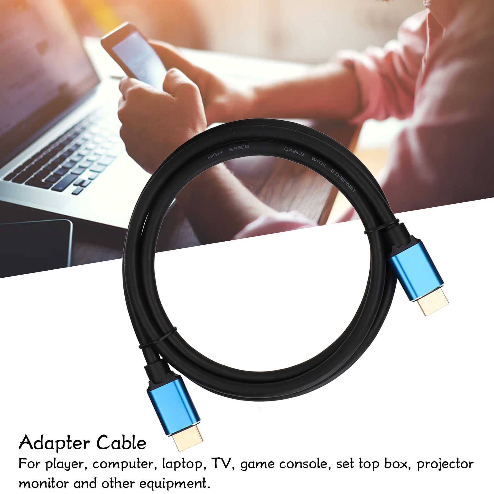 Ein schwarzes HDMI-Kabel mit blauen Steckern ist aufgerollt. Im Hintergrund benutzt eine Person einen Laptop und ein Telefon.