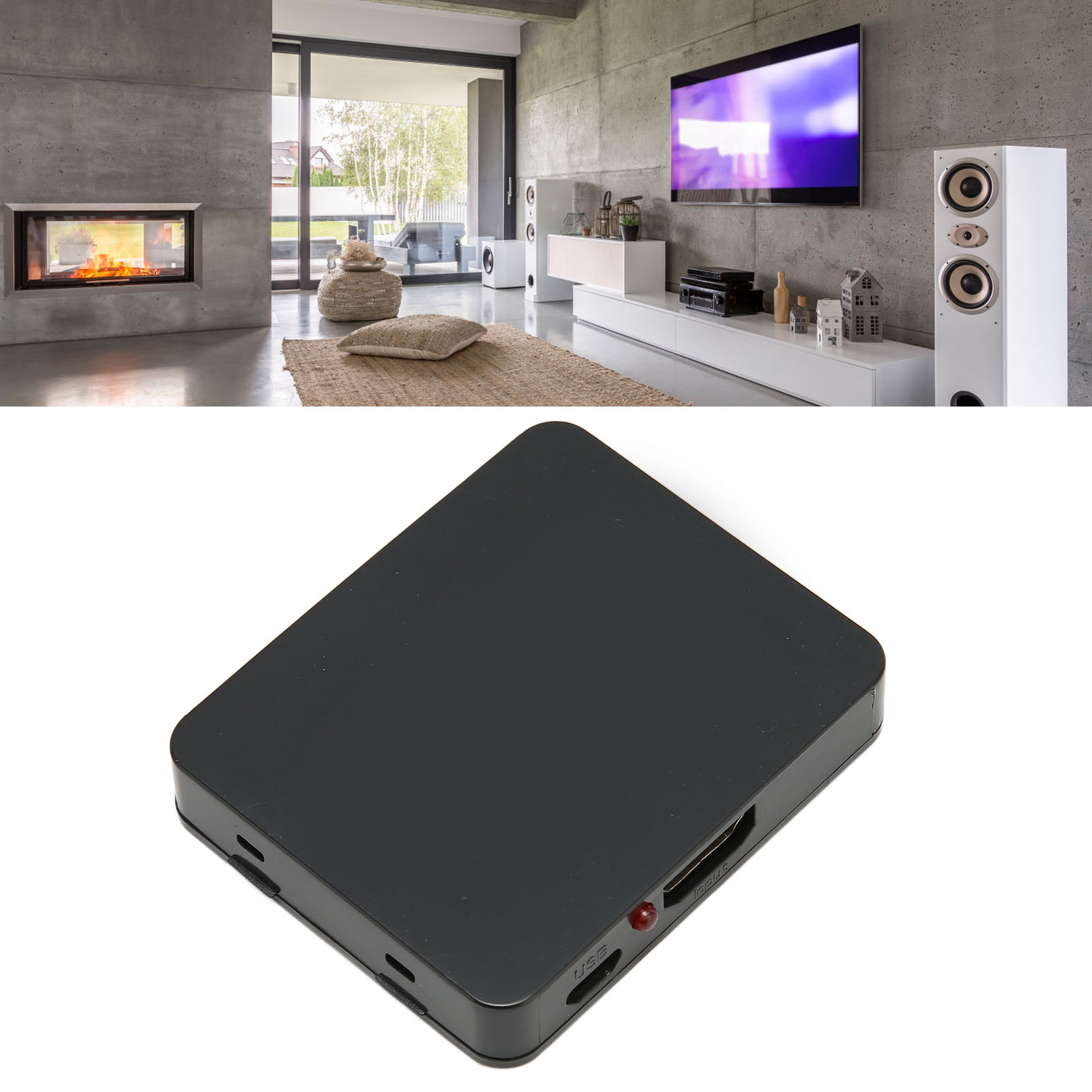 Ein schwarzer, rechteckiger Mediaplayer auf weißem Untergrund. Im Hintergrund ein modernes Wohnzimmer mit Kamin und TV.