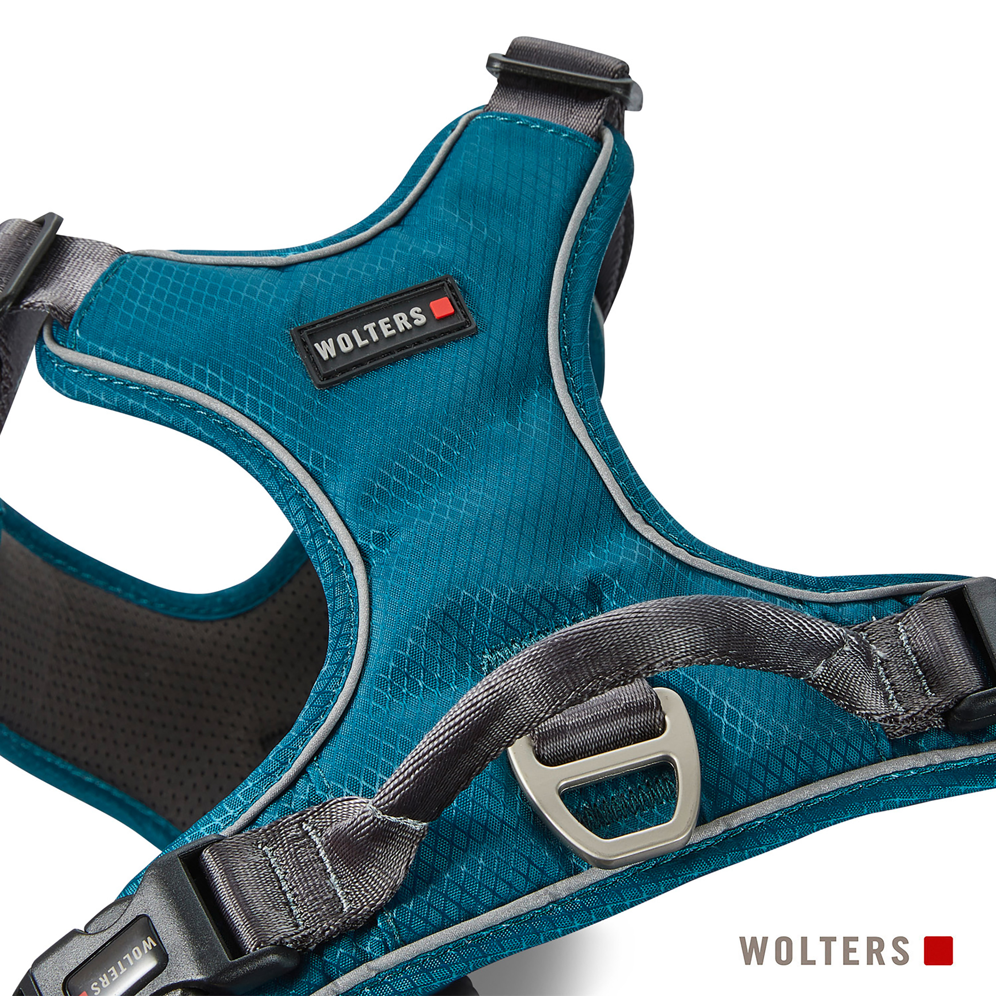 Nahaufnahme eines teal Hundegeschirrs mit grauen Akzenten, reflektierendem Besatz und dem Markennamen 'Wolters'.