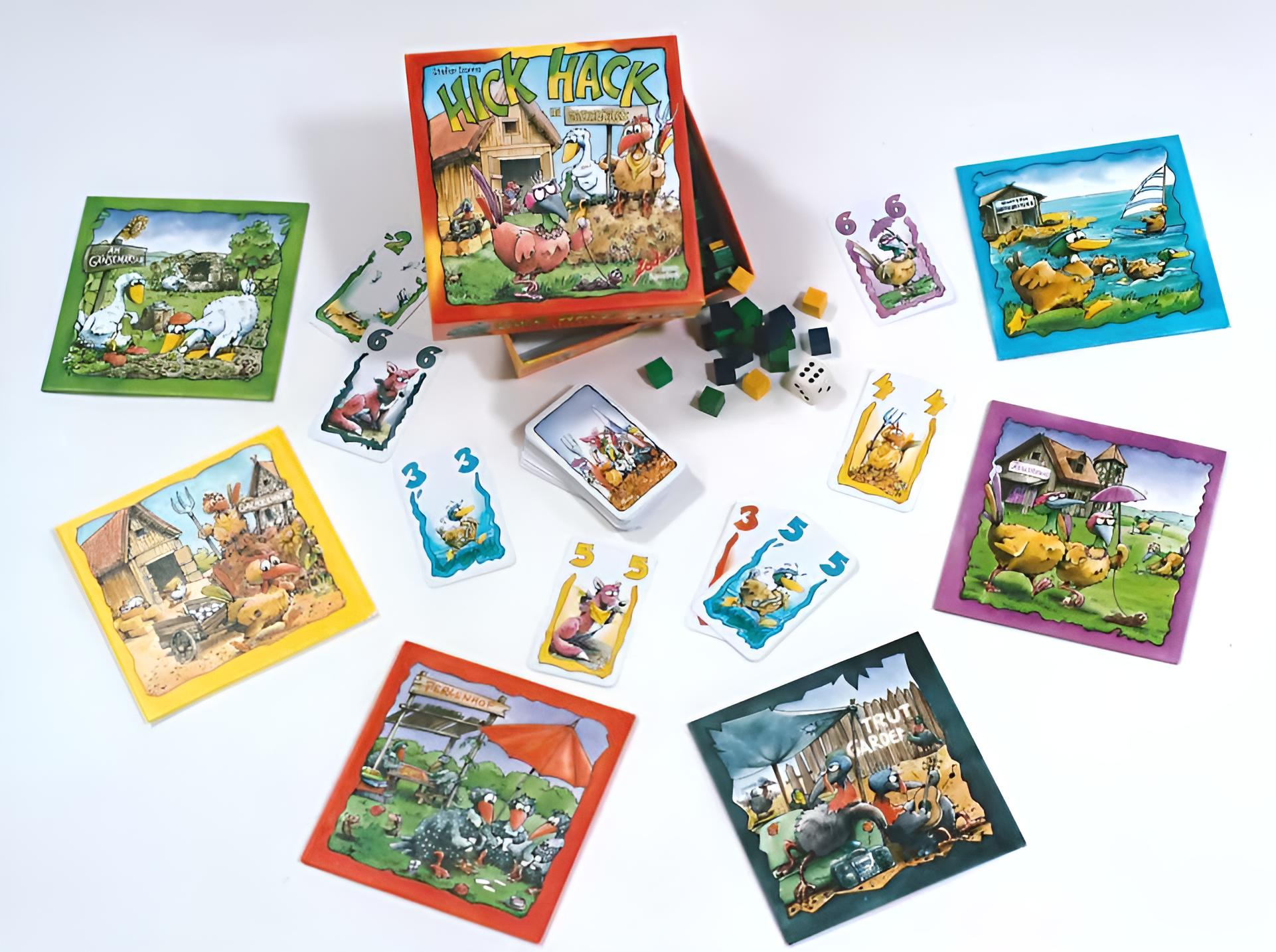 Das Brettspiel 'Hick Hack' wird gezeigt. Karten, Holzblöcke und Würfel sind verstreut. Die Box zeigt Bauernhoftiere.