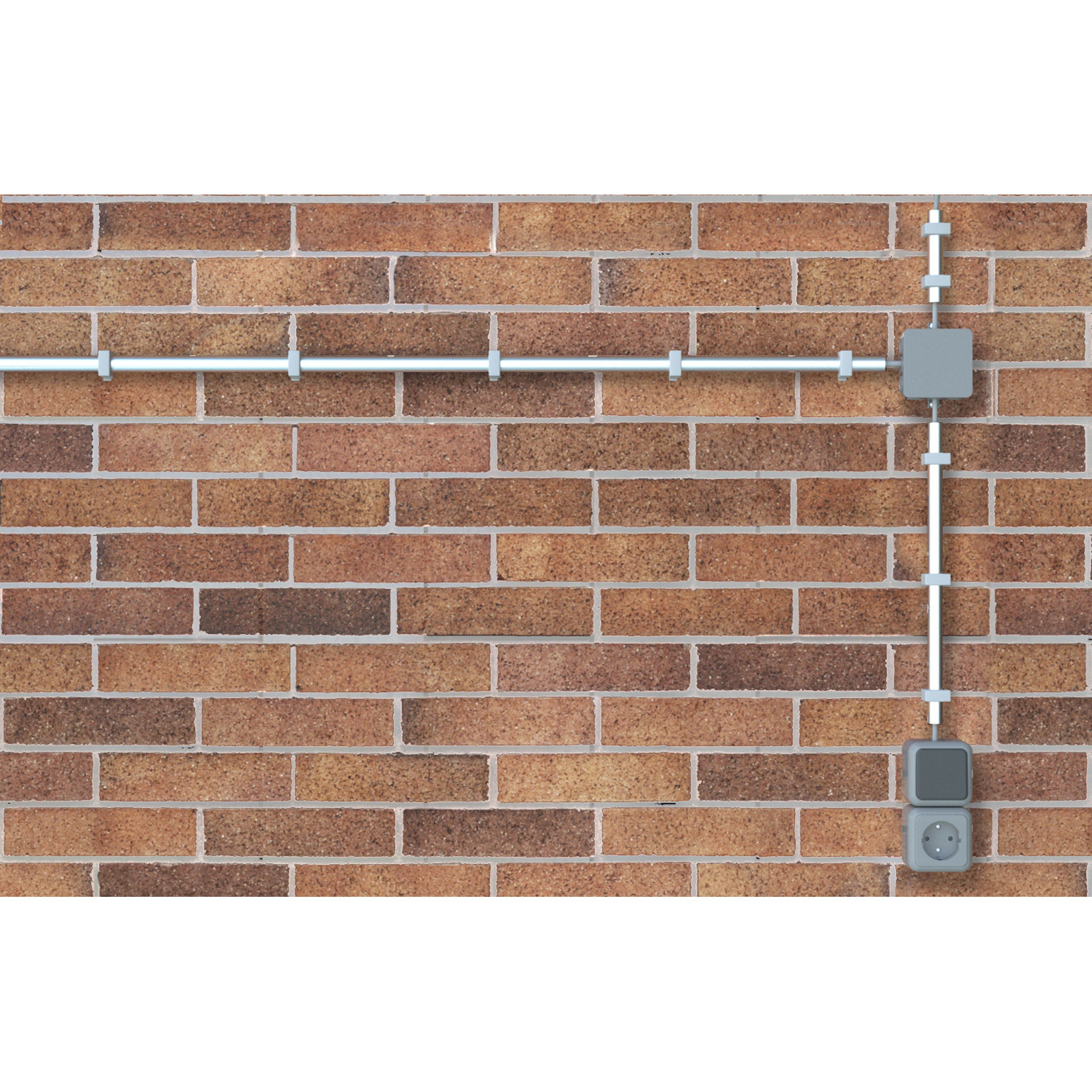 Eine Ziegelmauer mit elektrischen Leitungen und einer Steckdose. Die Leitung verläuft horizontal und vertikal mit einer Anschlussdose.