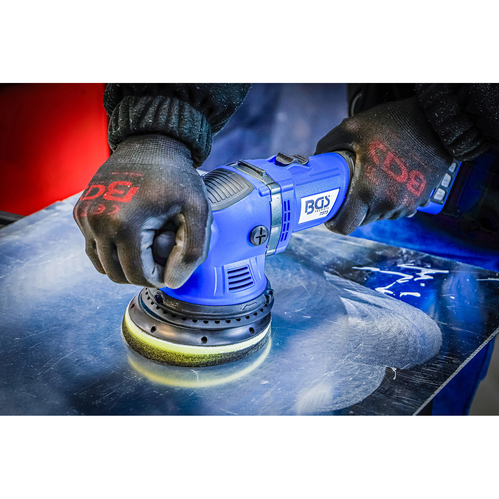 Hände mit Handschuhen halten einen blauen BGS-Polierer und polieren eine Metalloberfläche. Die Handschuhe haben das BGS-Logo.