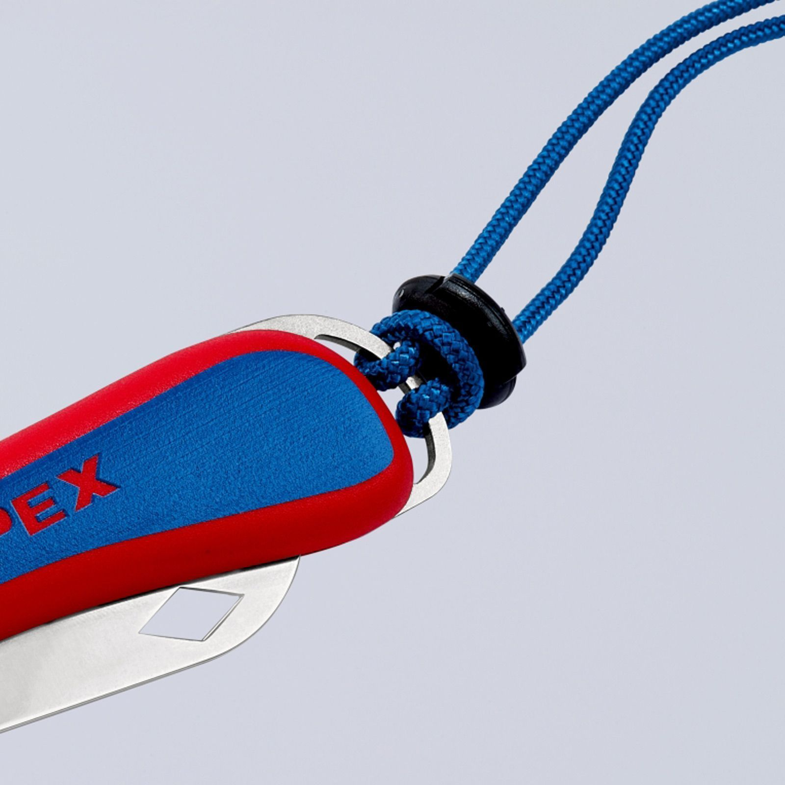 Una multiherramienta roja y azul con un cordón azul. Tiene una hoja plateada y está sobre un fondo blanco.
