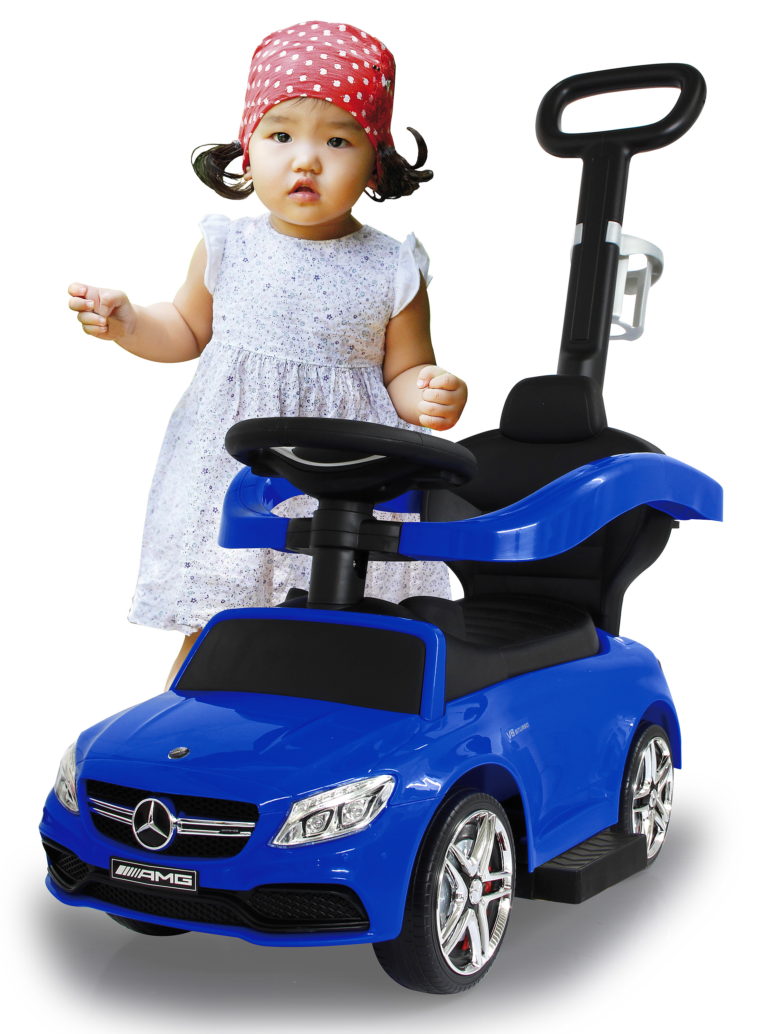 Un bambino con una bandana rossa a pois è accanto a un'auto giocattolo blu, con un manico nero.